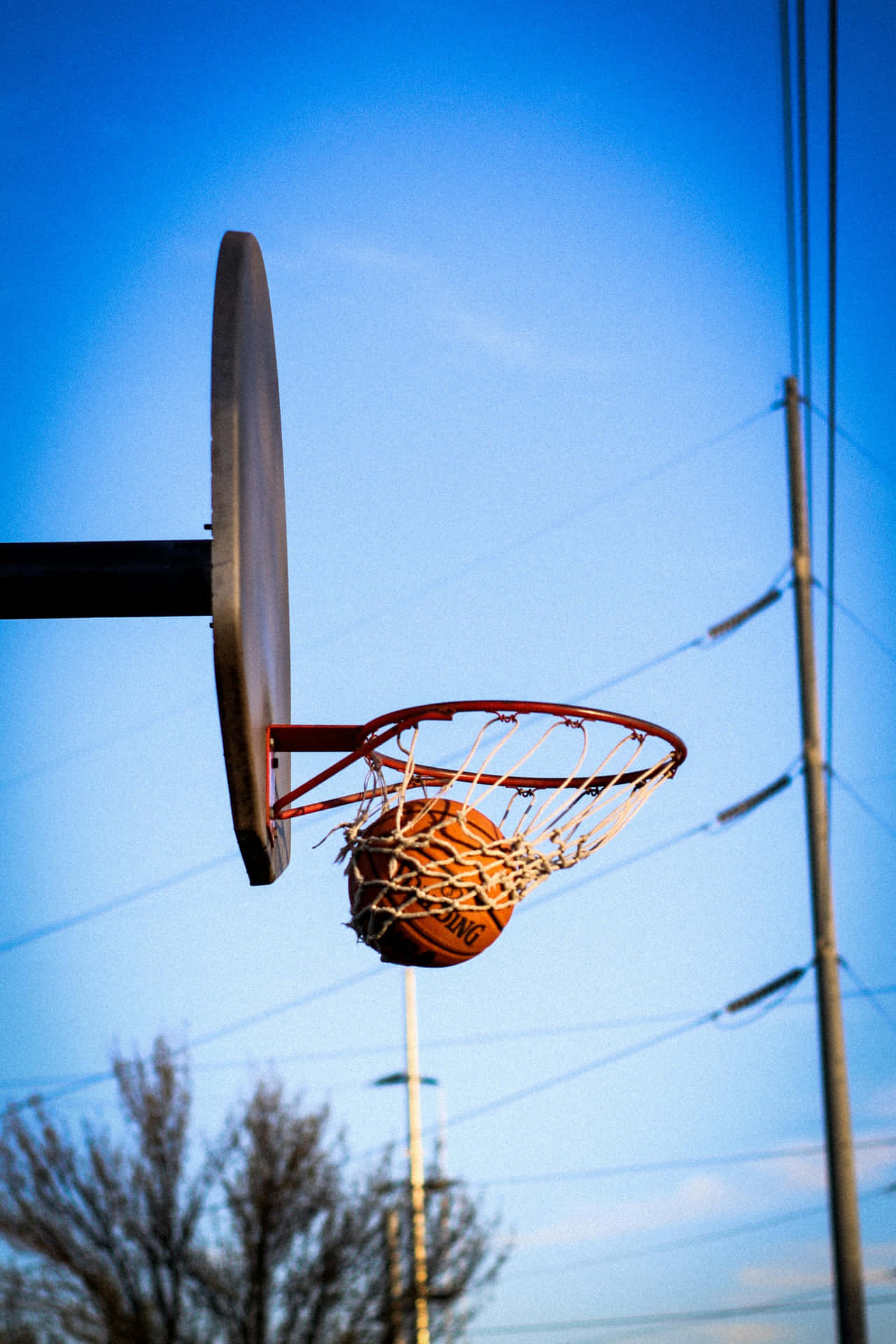 Basketball Swishing Through Hoop Outdoors Wallpaper