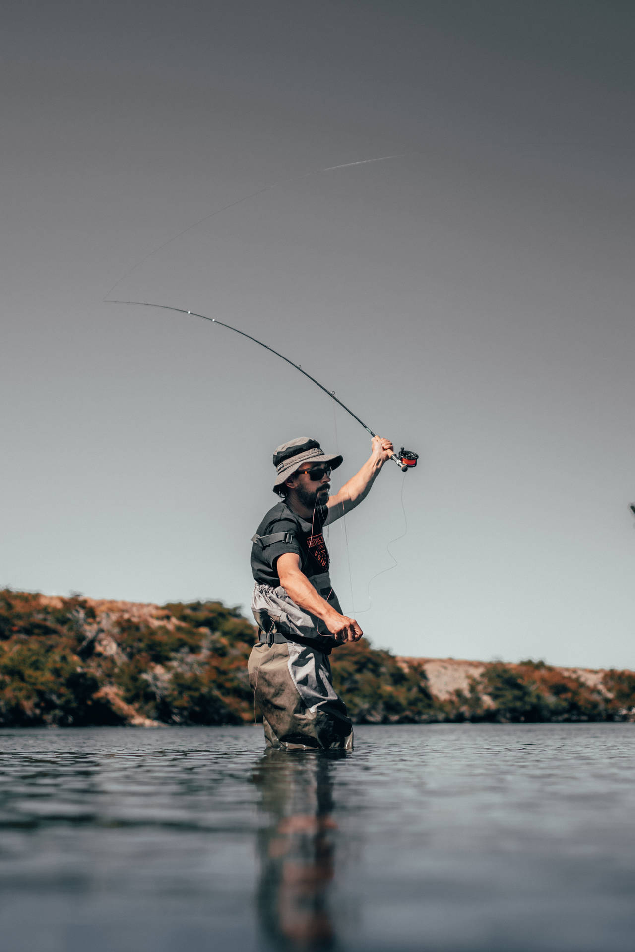 Pescandolobinas Con Un Señuelo Cuchara En Un Lago Sereno. Fondo de pantalla