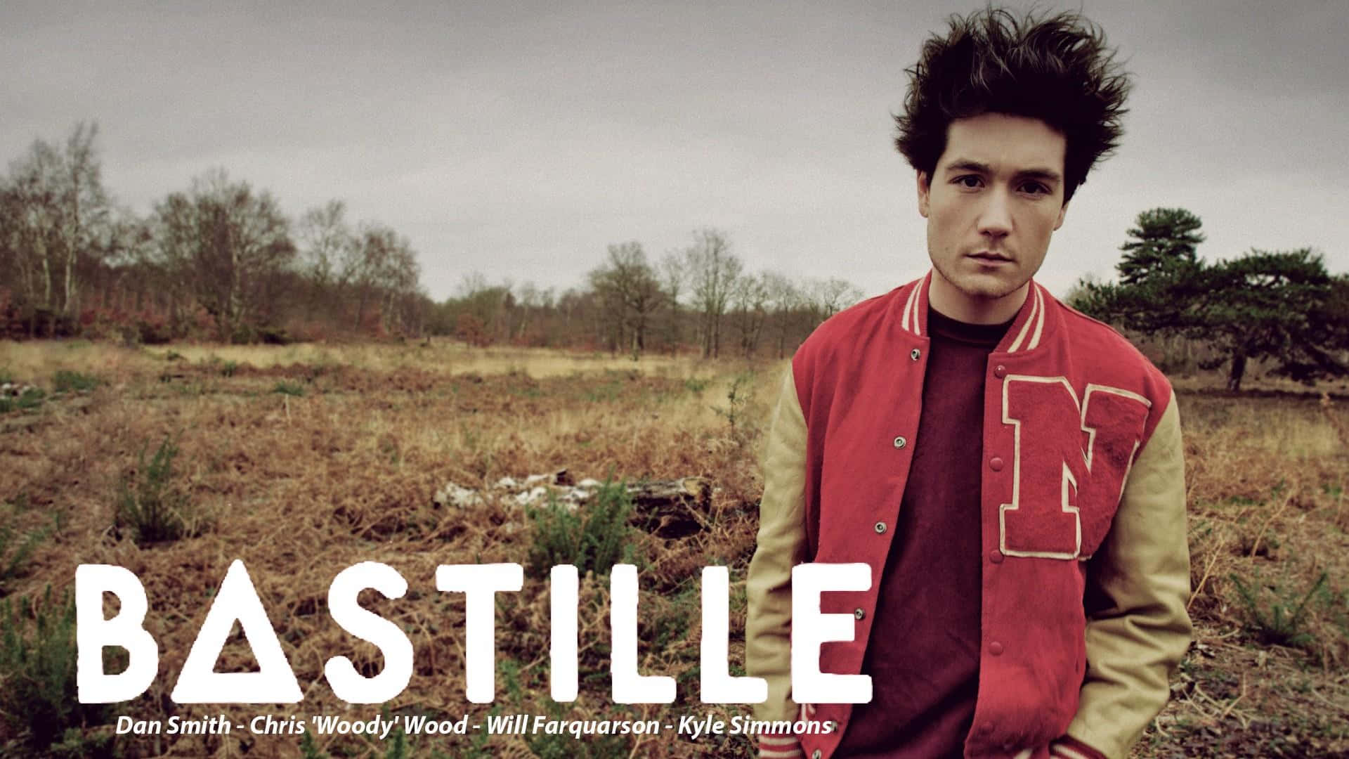 Bastilles - A Man In A Red Jacket Standing In A Field