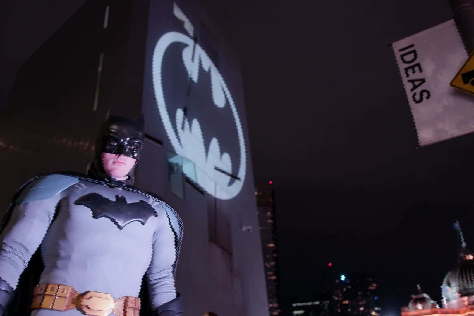 The iconic Bat Signal lighting up the night sky Wallpaper
