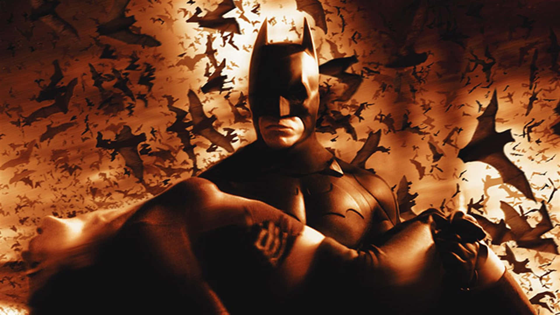 Batman standing tall in a dark and intriguing atmosphere in Batman Begins Wallpaper