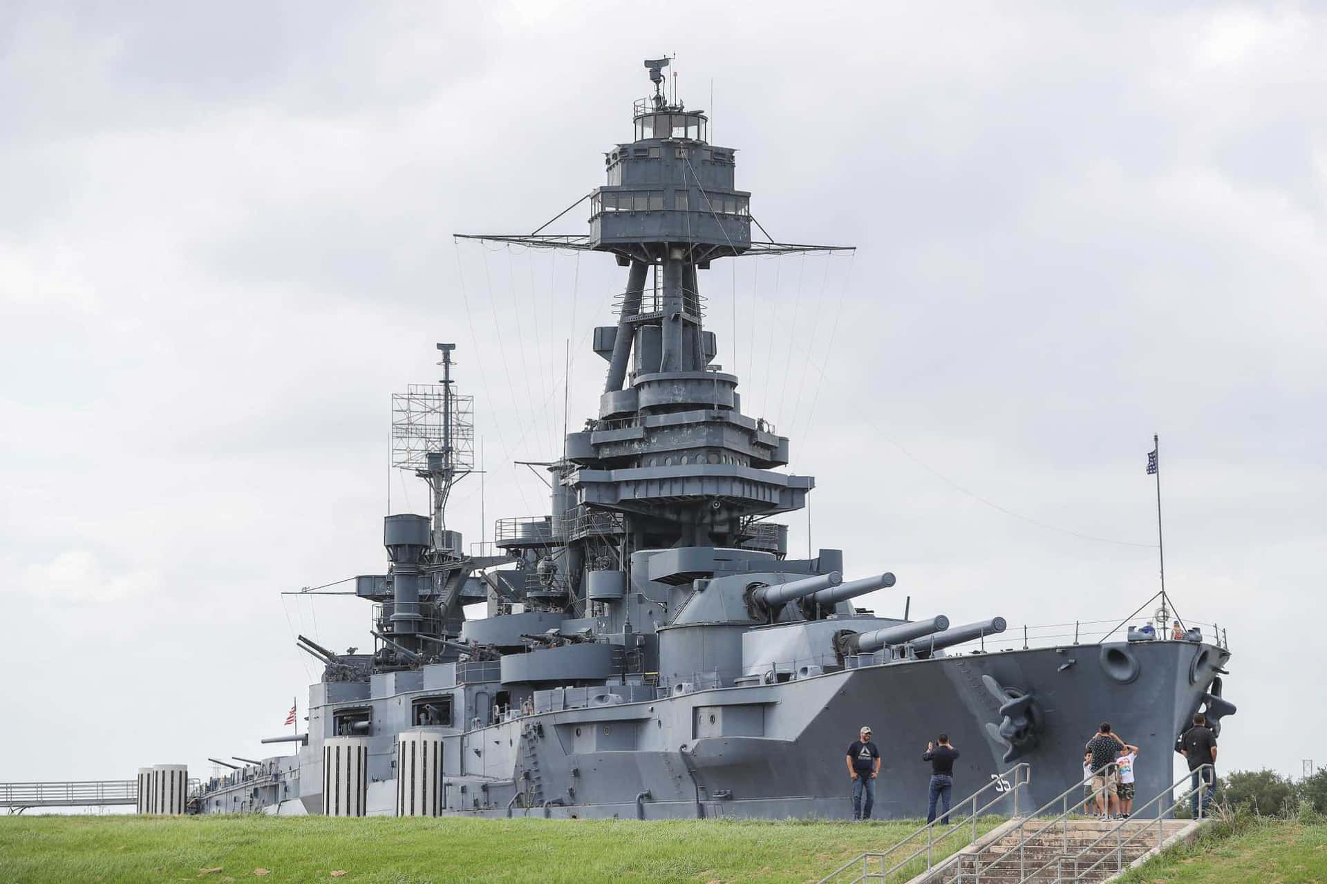 a battleship is on display in a grassy area