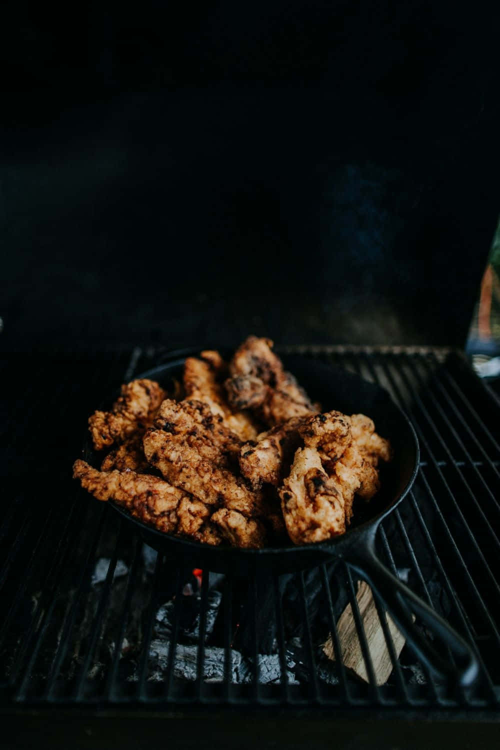 A Skillet Of Chicken On A Grill