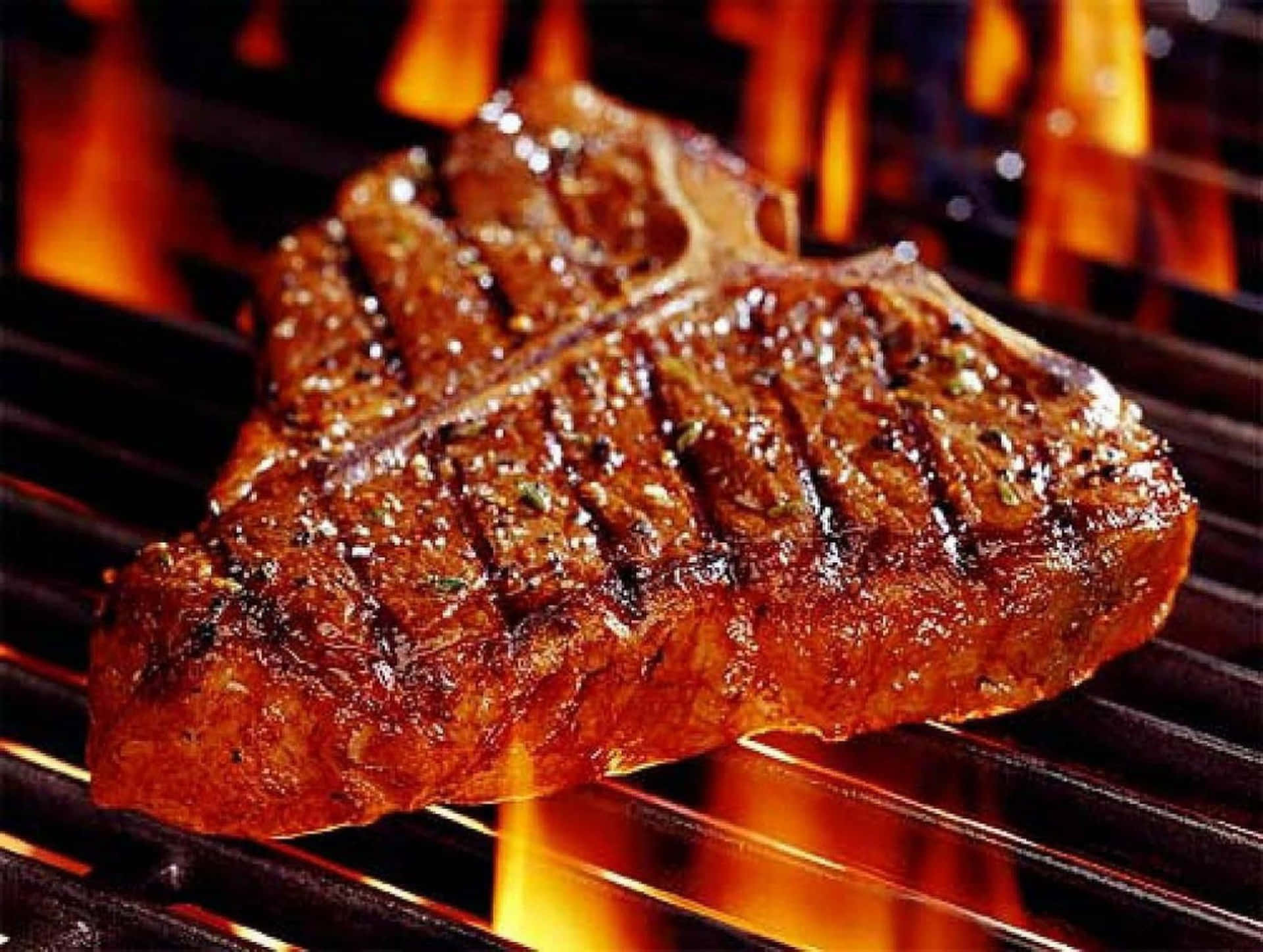A Steak Is Being Cooked On A Grill With Flames