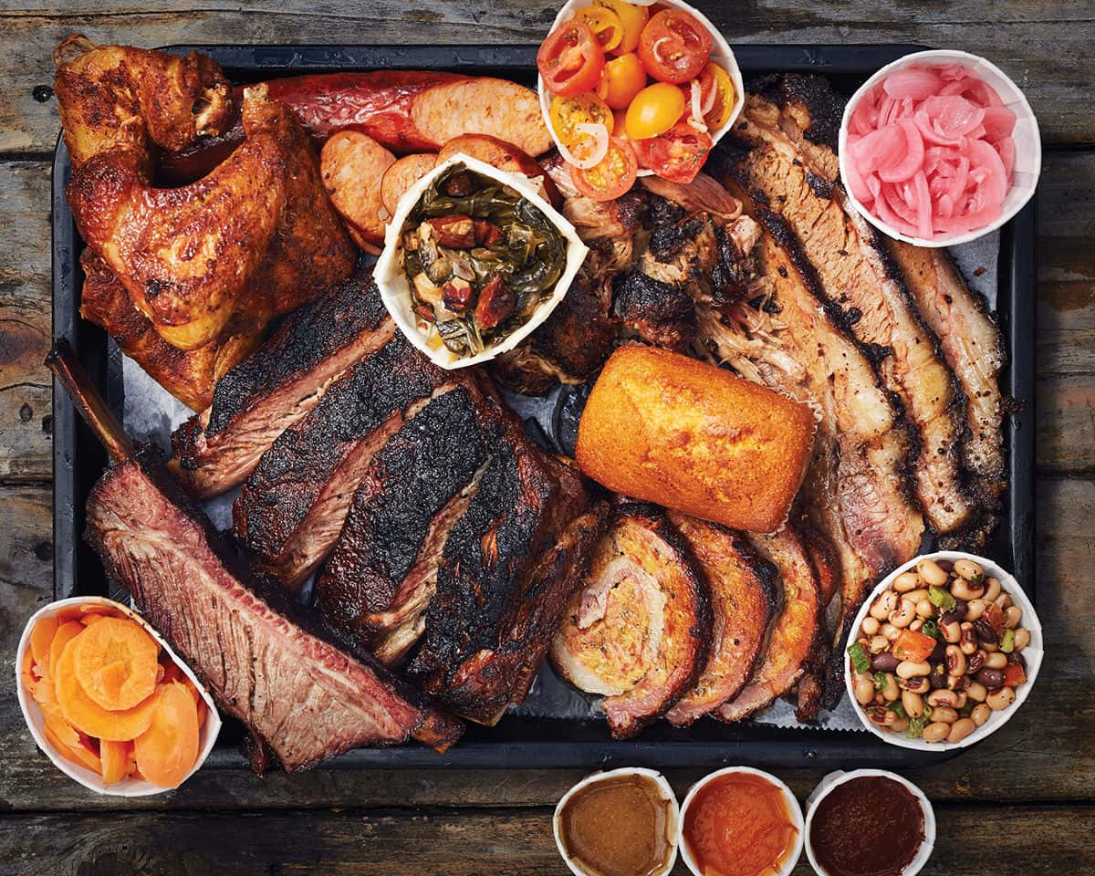 A Tray Of Meat And Vegetables On A Wooden Table