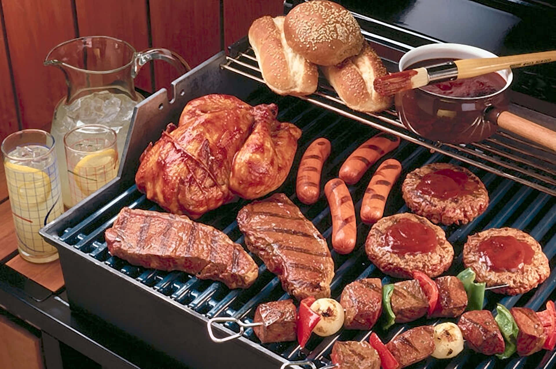 A Grill With Meat, Vegetables, And Condiments