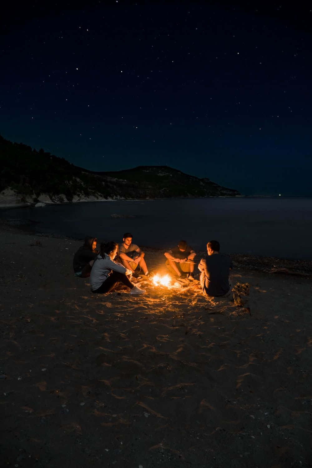 Beach Bonfire under a starry night sky Wallpaper