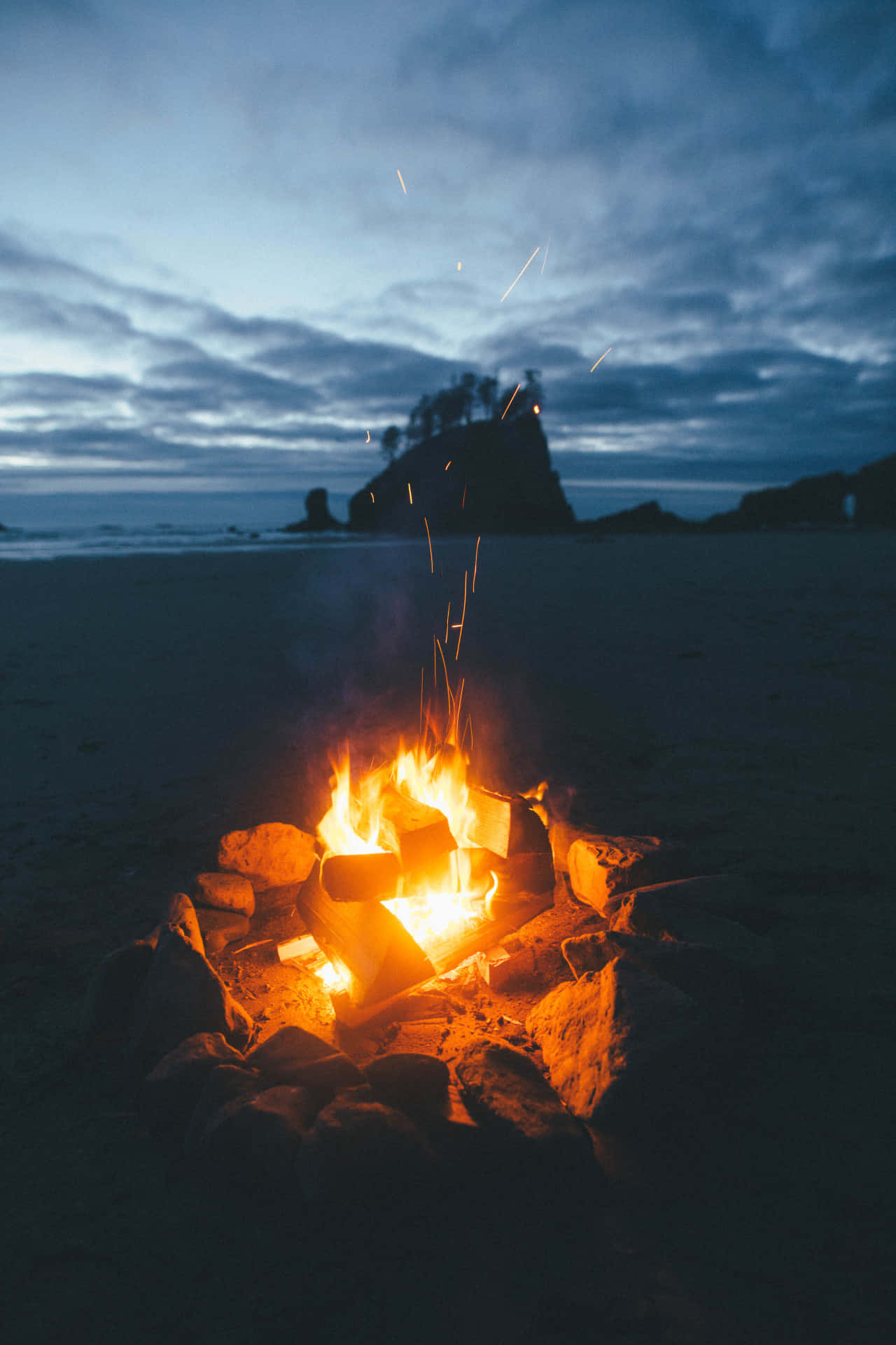 Warm Beach Campfire Under The Starry Night Sky Wallpaper