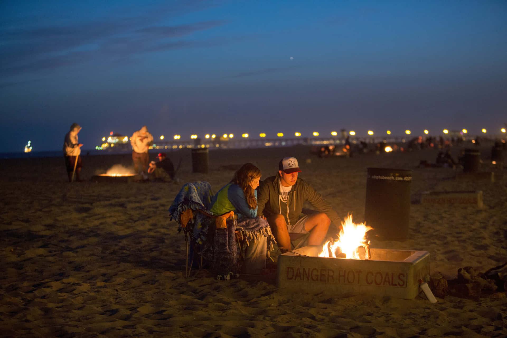 A Cozy Beach Campfire Under A Twilight Sky Wallpaper