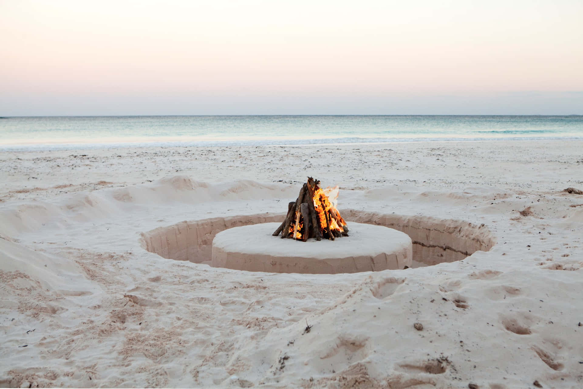 A Cozy Beach Campfire At Sunset Wallpaper