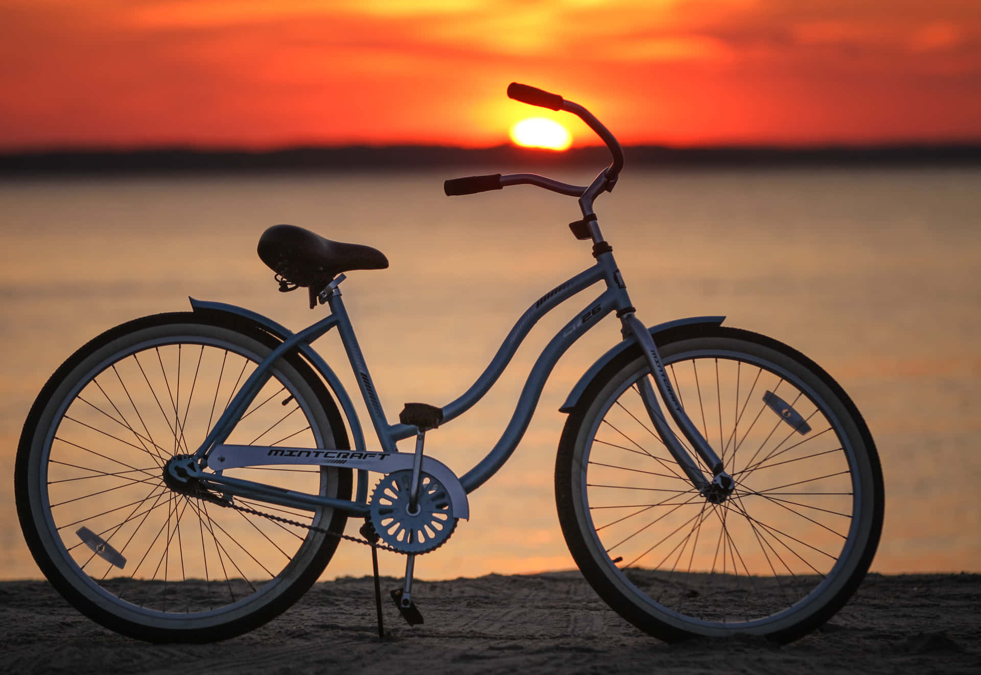 A vibrant beach cruiser bicycle on a sandy beach. Wallpaper