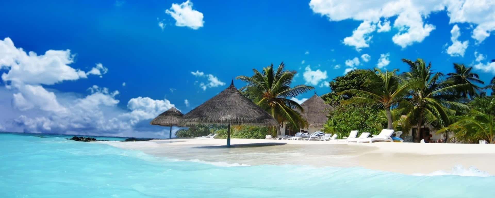 A Beach With Chairs And Umbrellas On The Water Wallpaper