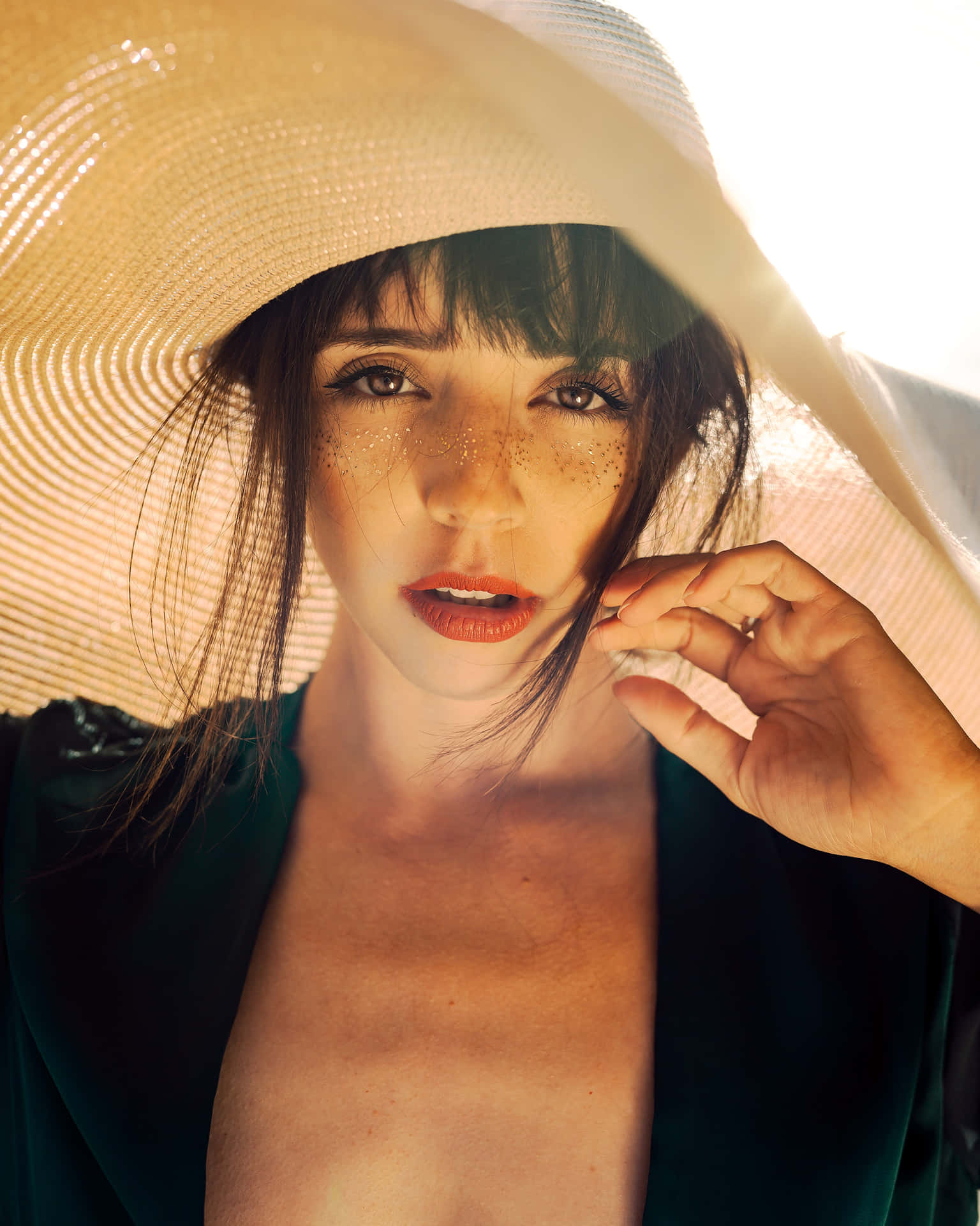 Stylish beach hat lying on a sandy shore Wallpaper