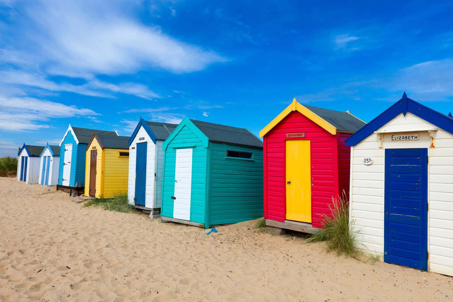 Colorful Beach Huts on a Sunny Day Wallpaper