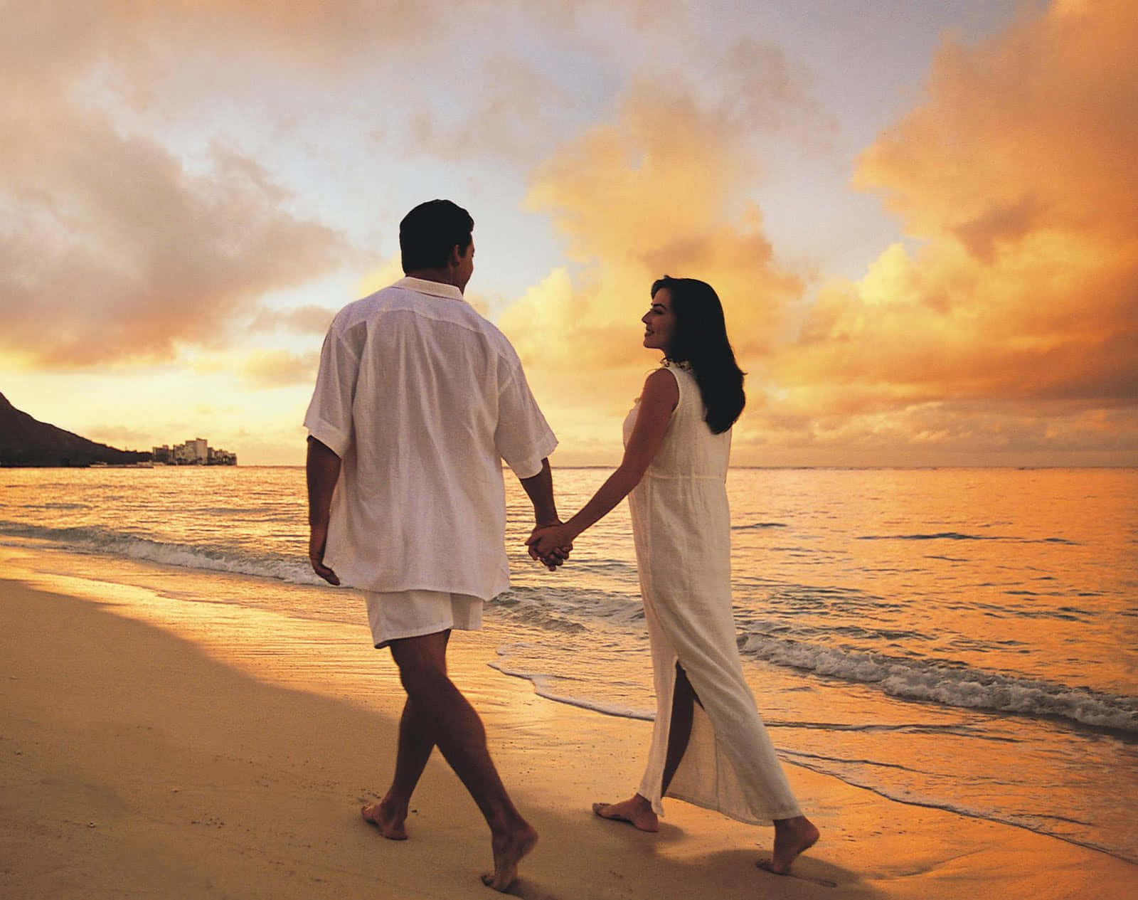 Couple enjoying a romantic sunset on a tropical beach Wallpaper