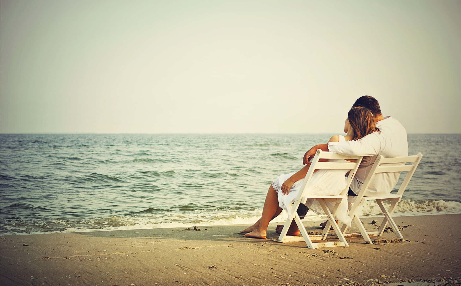 Couple Enjoys a Romantic Sunset on the Beach Wallpaper