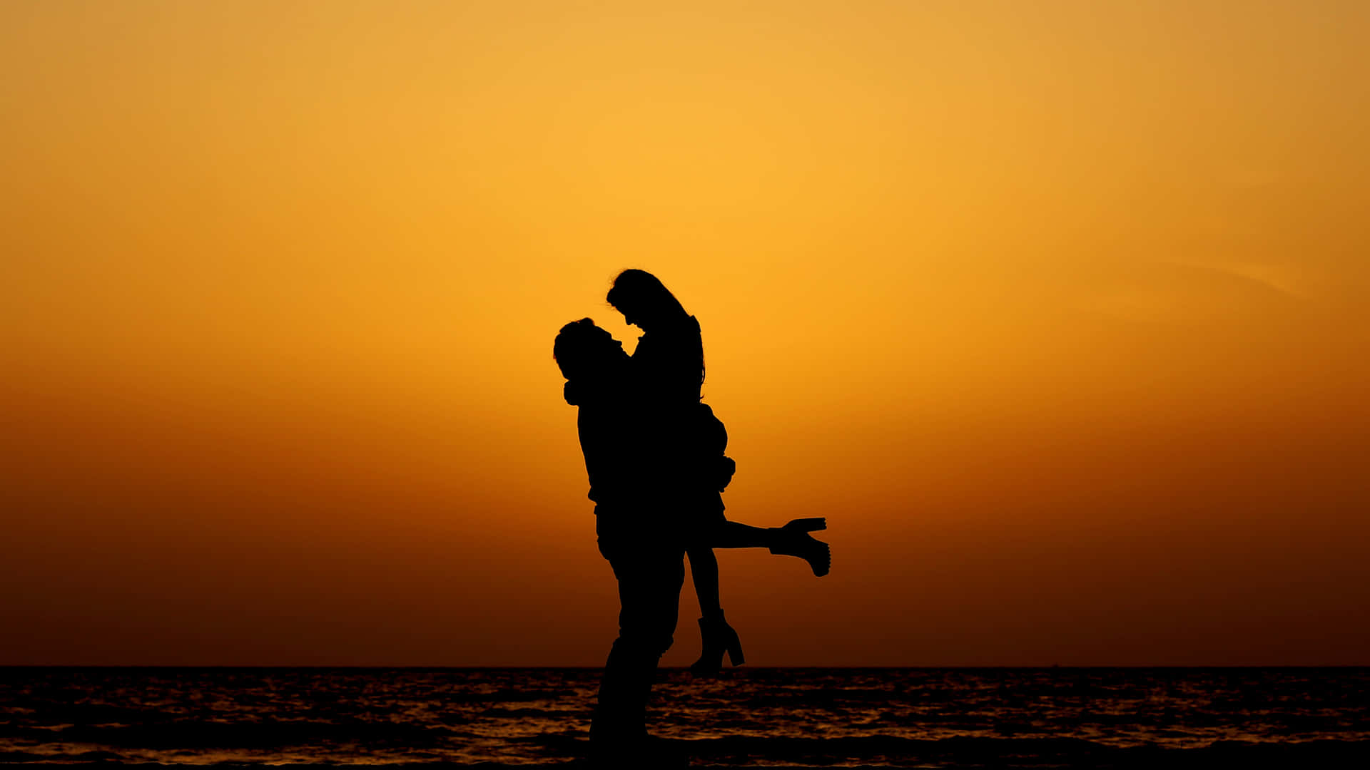 Caption: Sunset Embrace at the Seashore Wallpaper