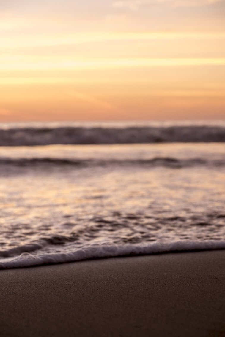En mand står på stranden ved solnedgang. Wallpaper