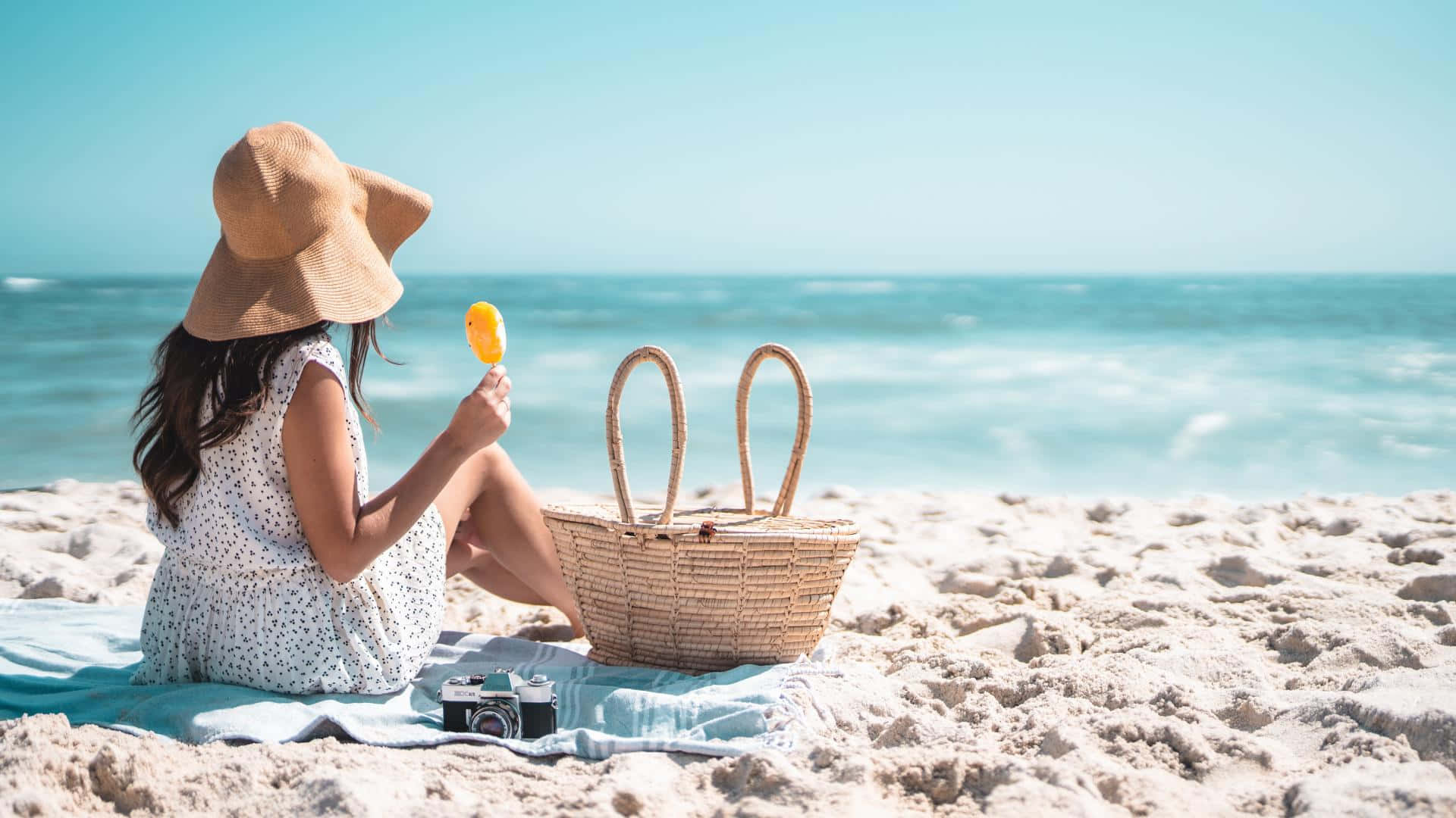 A Relaxing Beach Picnic Setup with Snacks and Pillows Wallpaper