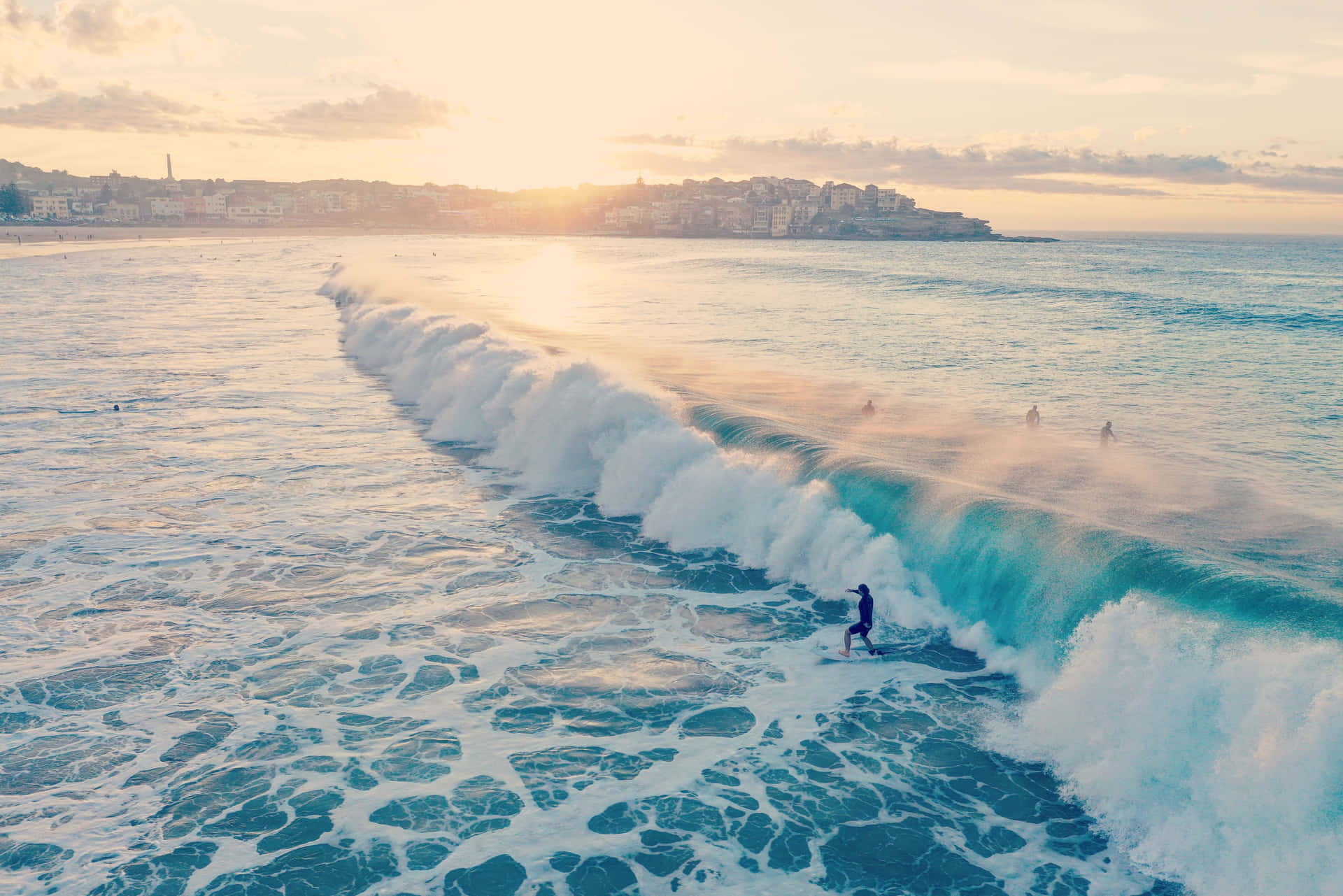 A Surfer Is Riding A Wave At Sunset