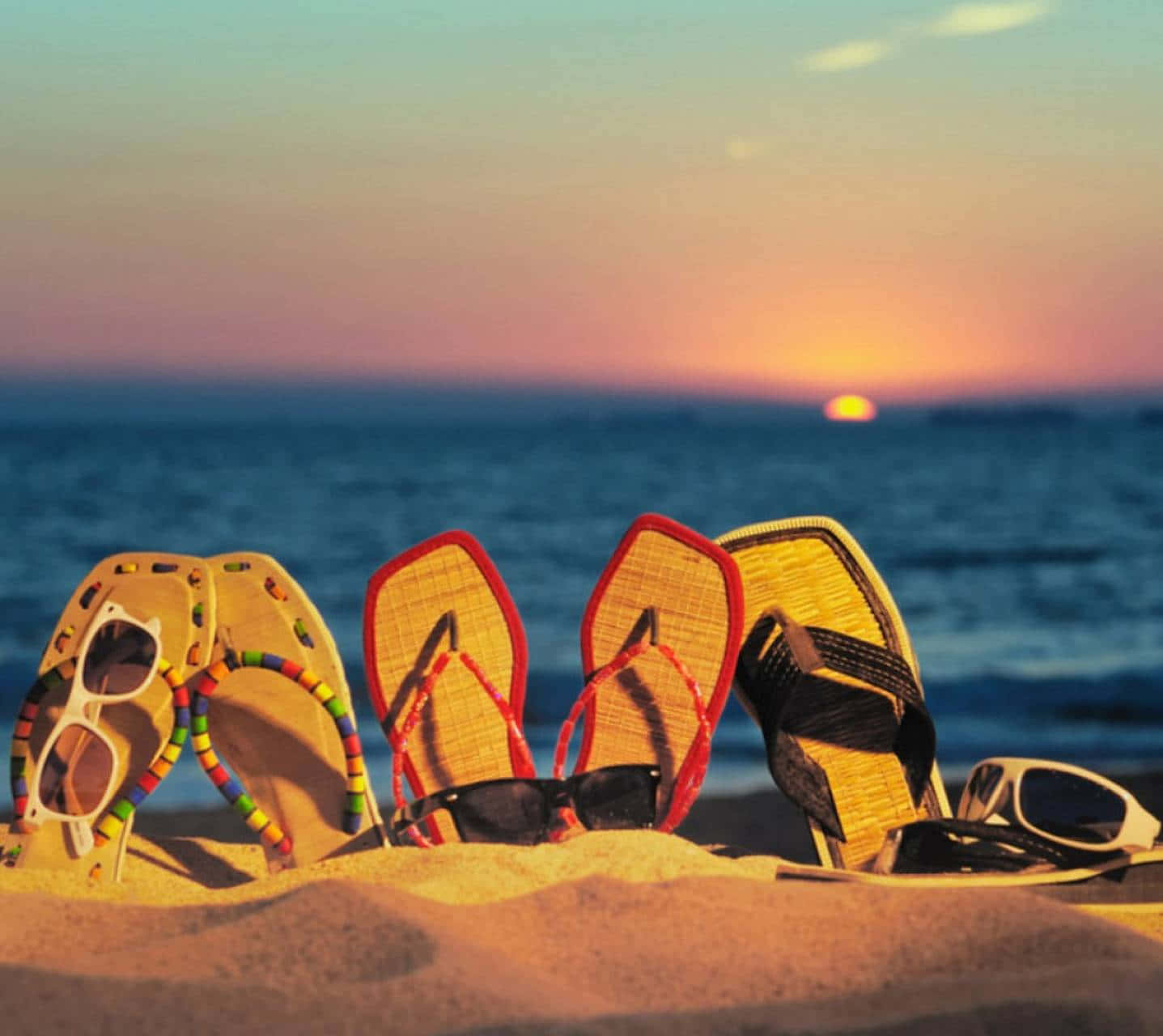 Relaxing Beach Sandals on a Sunny Shore Wallpaper