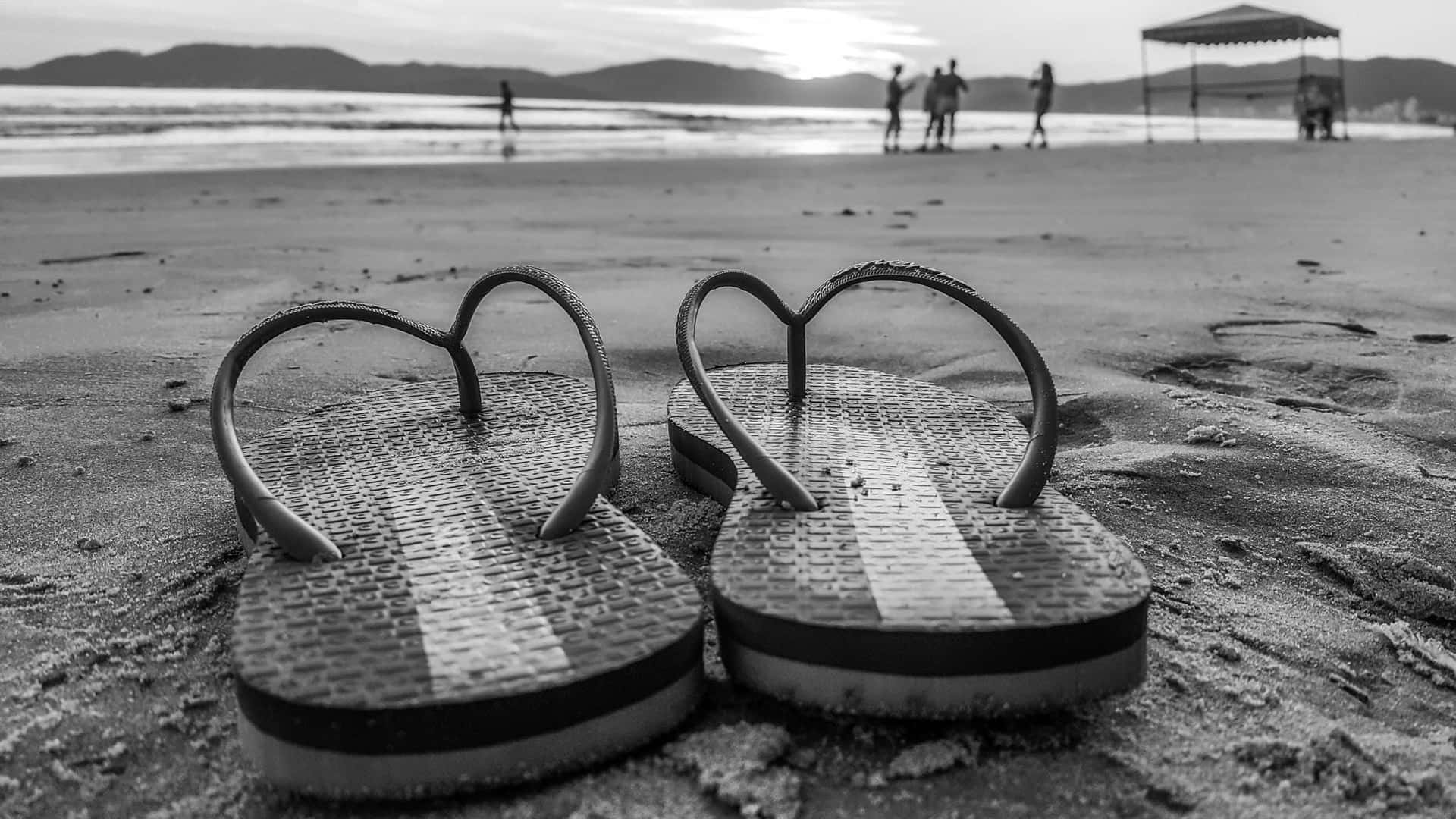 Summertime Relaxation: Beach Sandals Awaiting the Shore Wallpaper