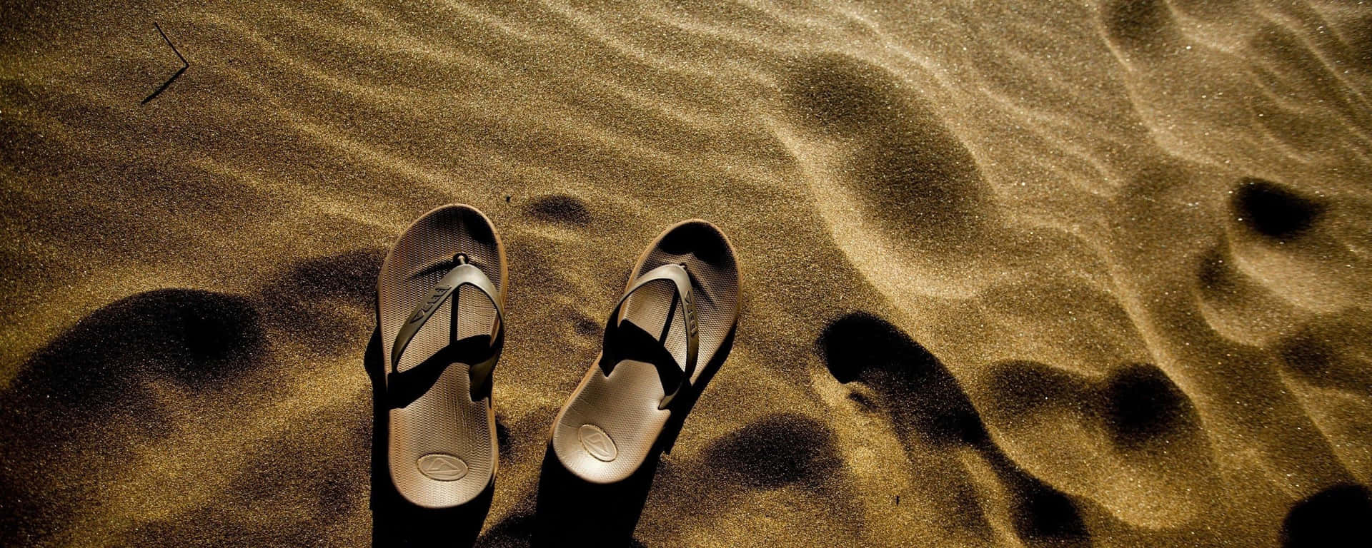 Vibrant Beach Sandals on Sandy Shoreline Wallpaper