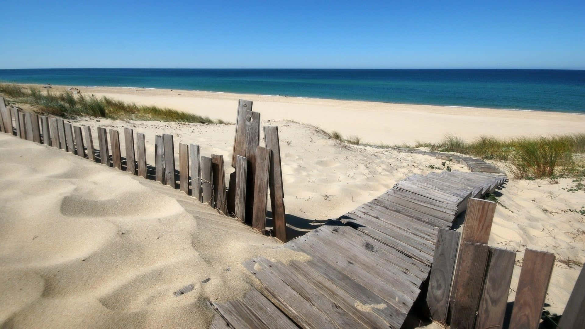 A Wooden Walkway Leading To A Beach