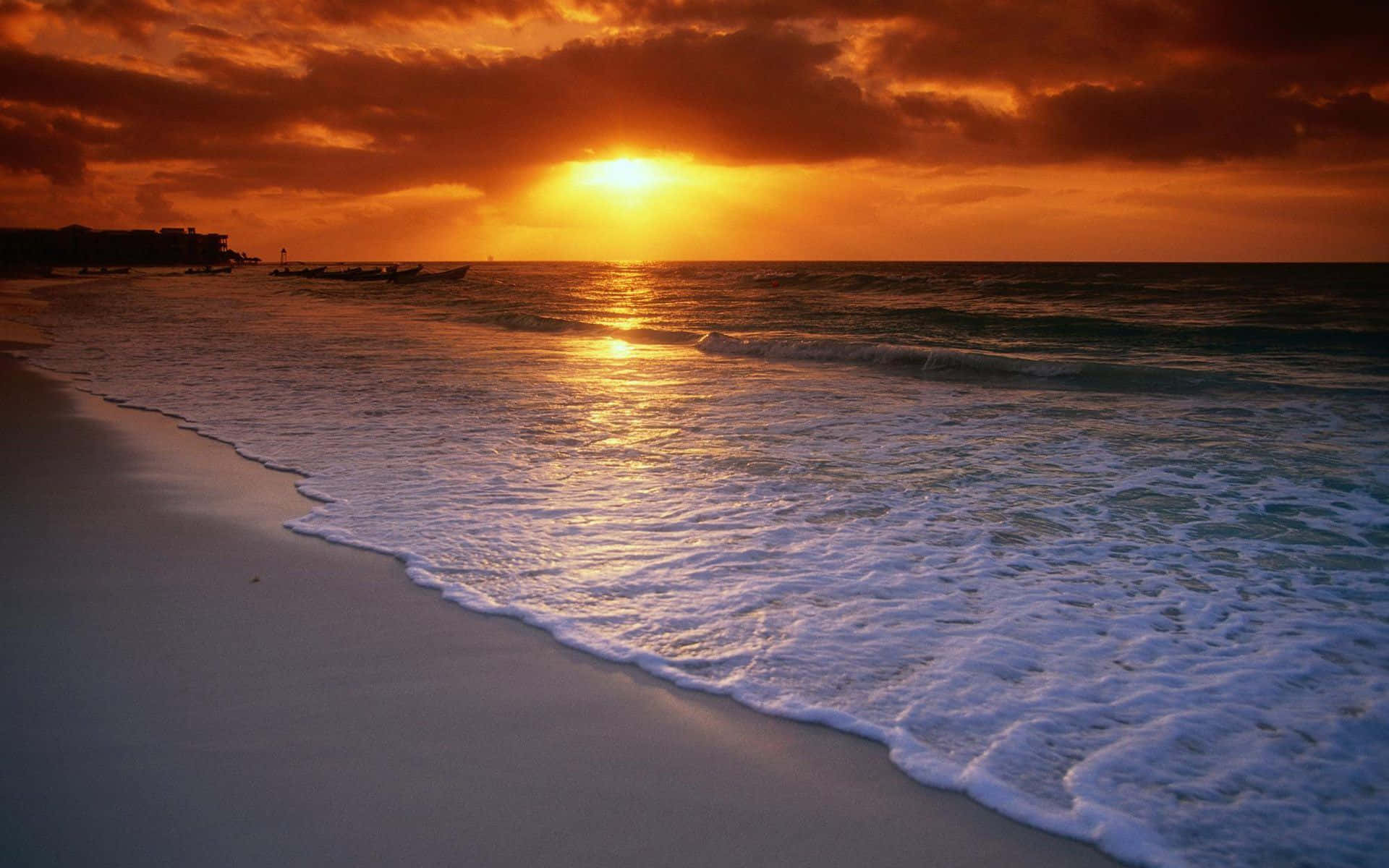 En strand med bølger og en solnedgang