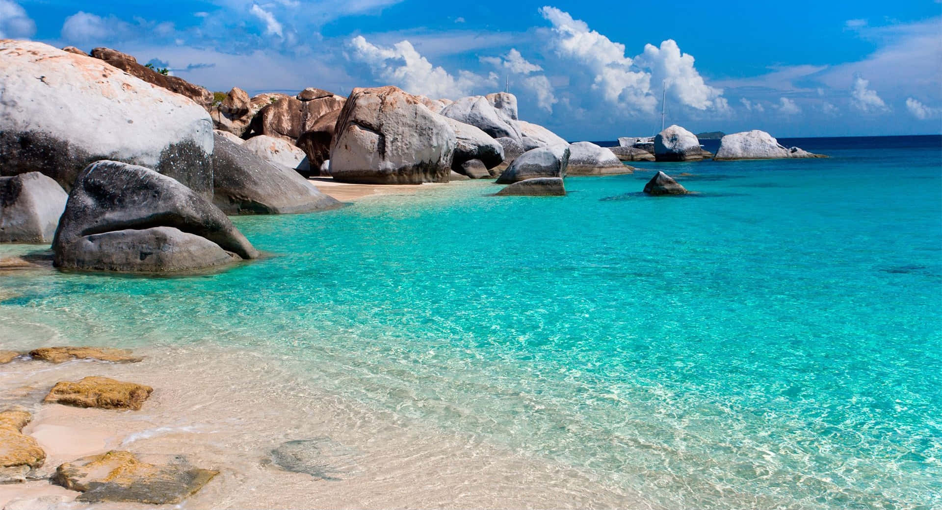 a beach with clear water and rocks
