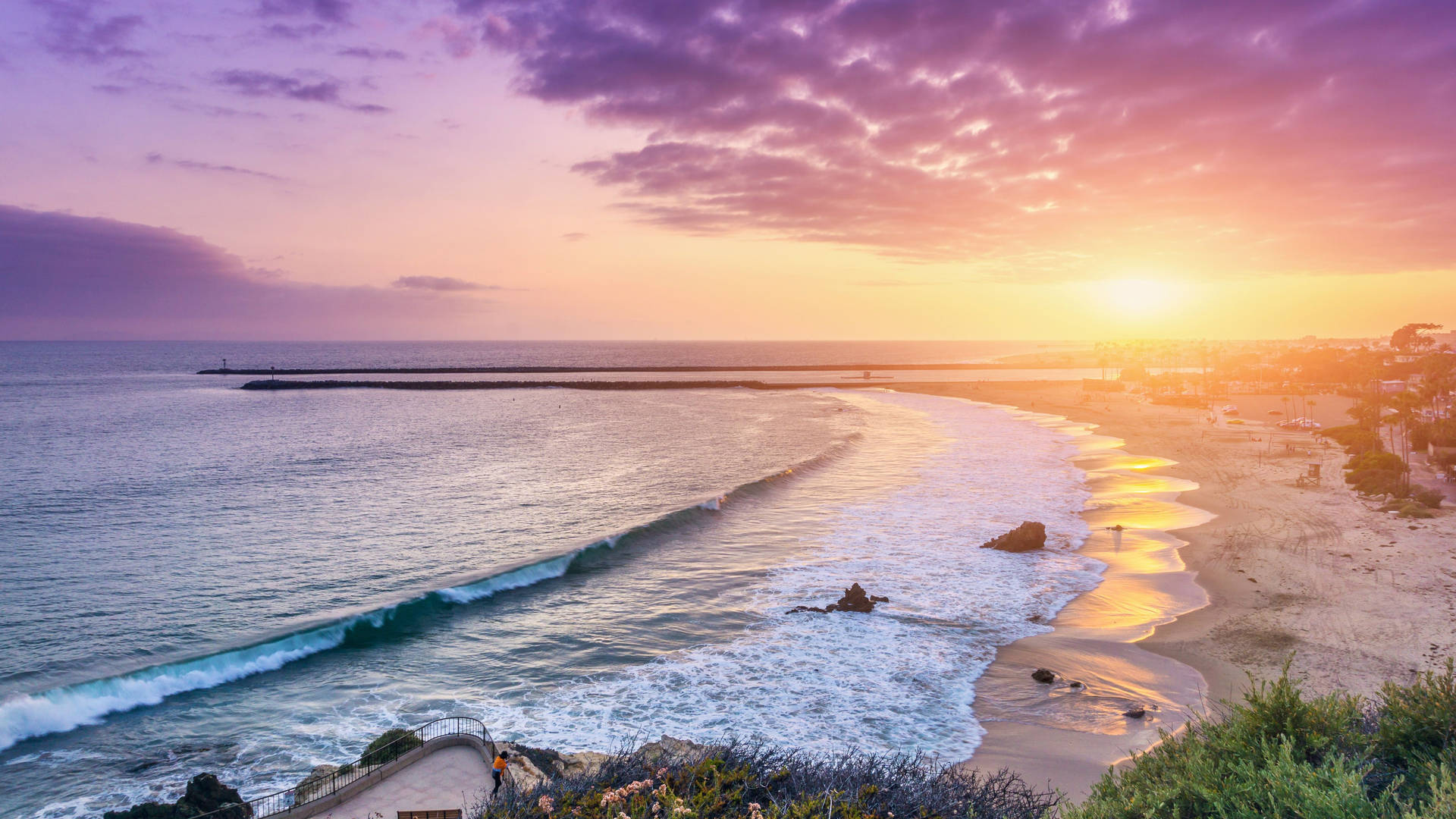 A Sunset Over The Ocean At A Beach Wallpaper