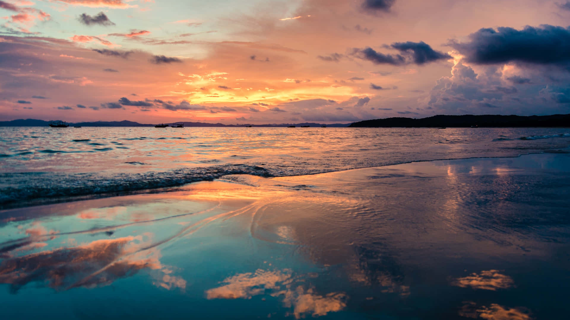 En strand med solnedgang over havet Wallpaper