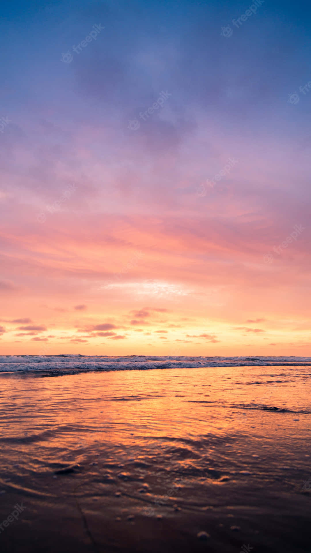 Unapuesta De Sol En La Playa Con Un Cielo Colorido Fondo de pantalla