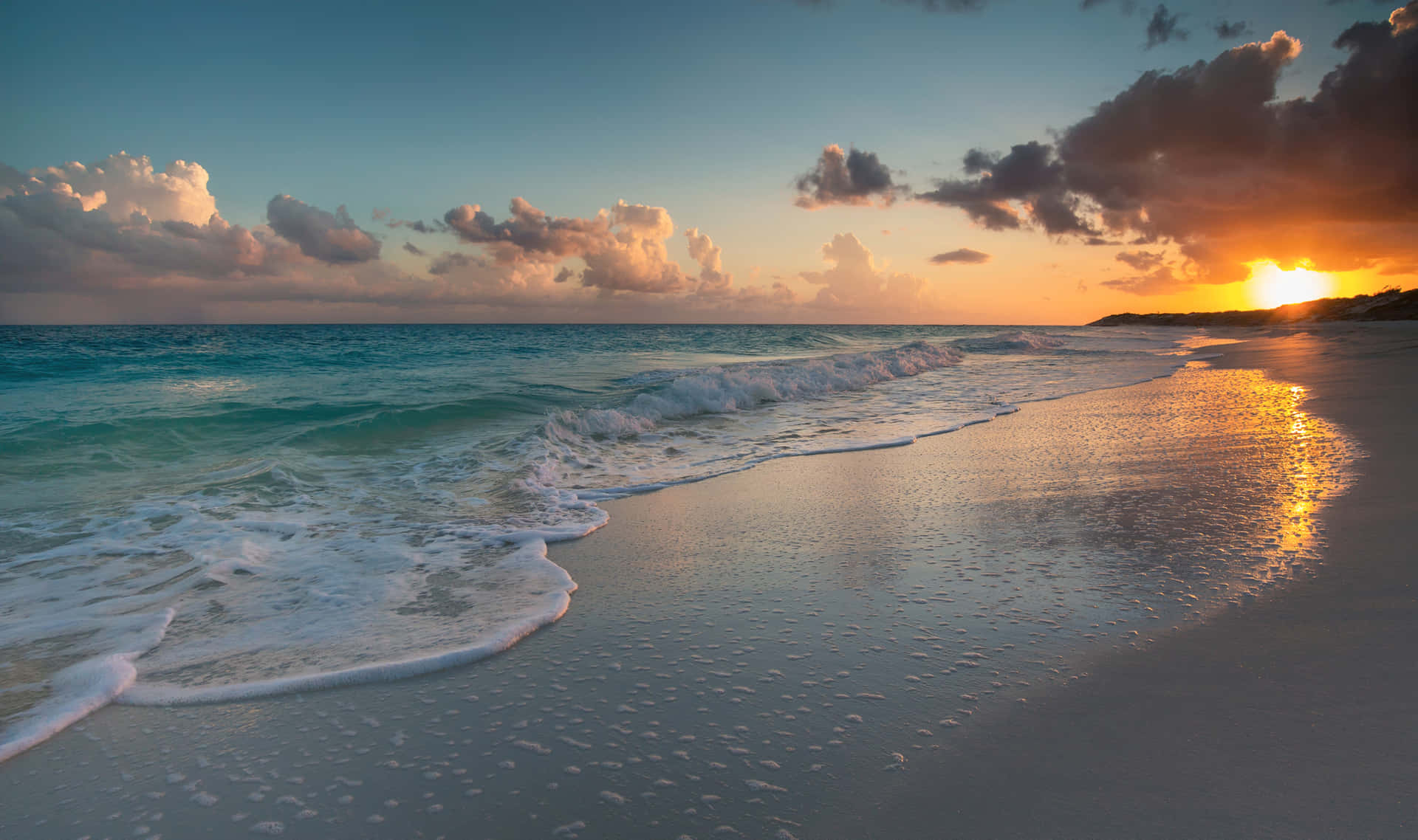 Watch the sky light up in a beautiful sunrise with the backdrop of a calm beach.