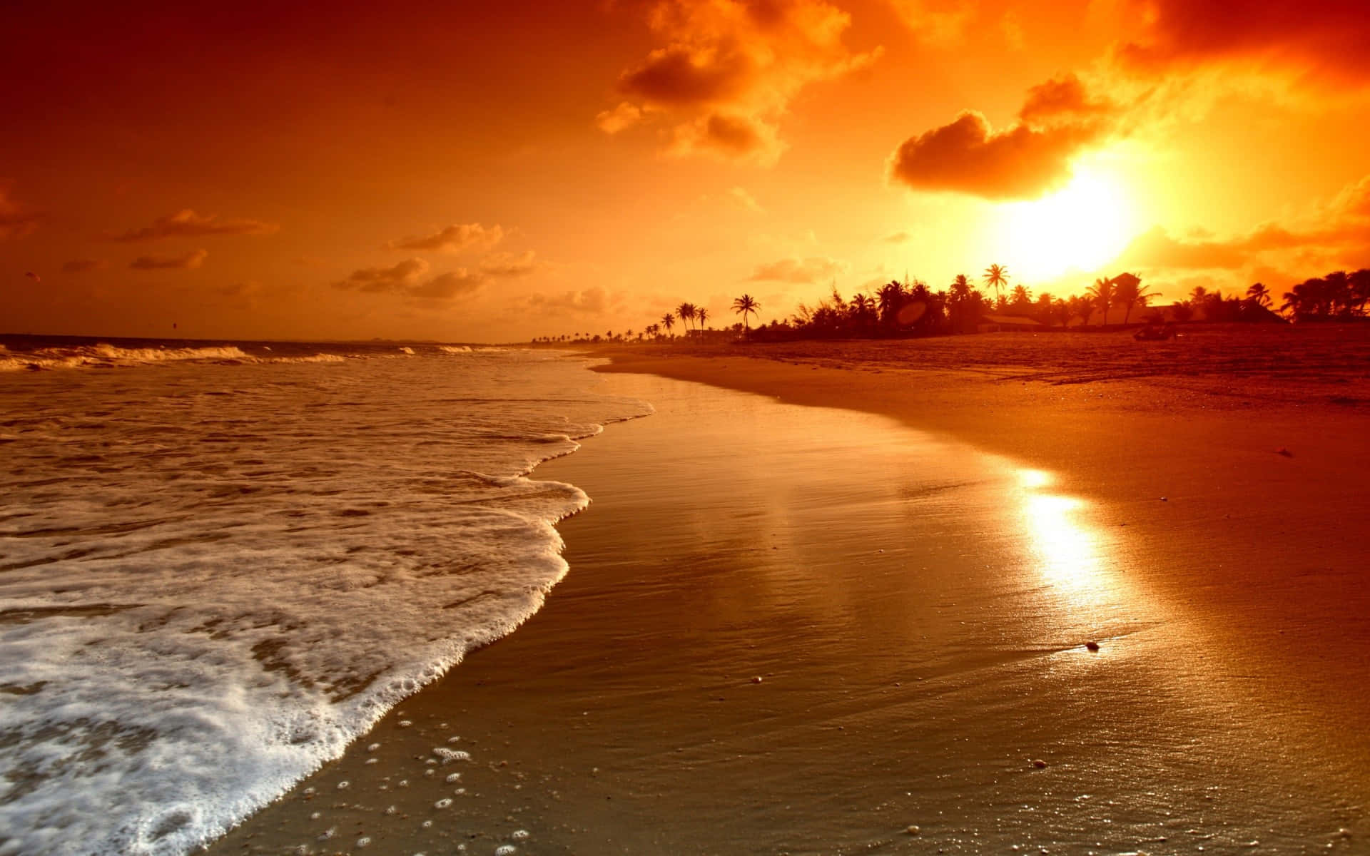 A Sunset On A Beach With Waves Wallpaper