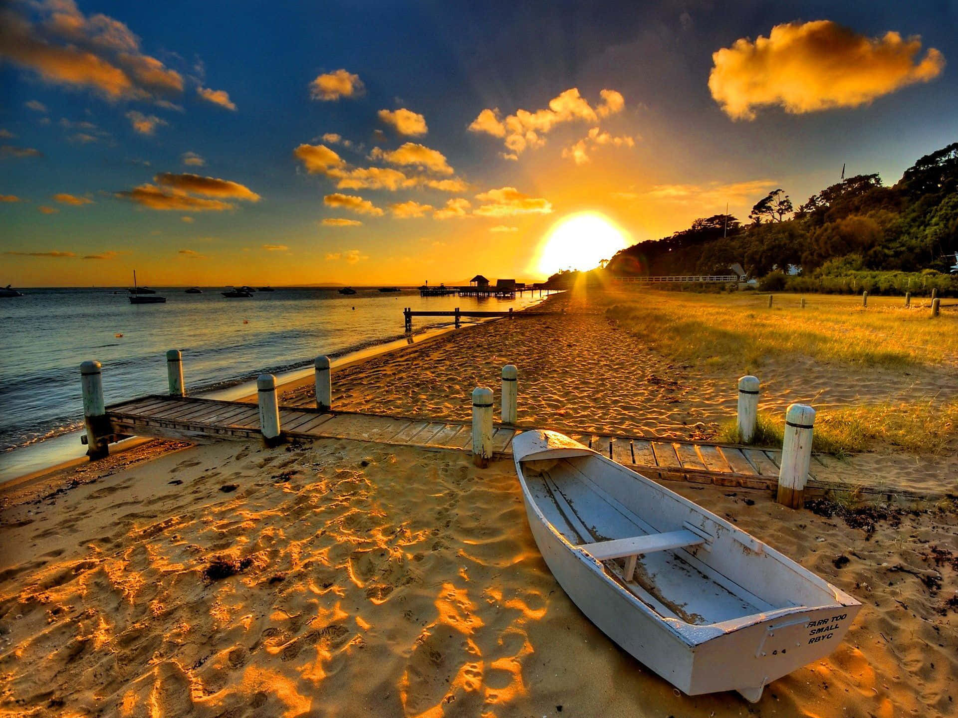 Nyd skønheden af et solnedgang på stranden. Wallpaper