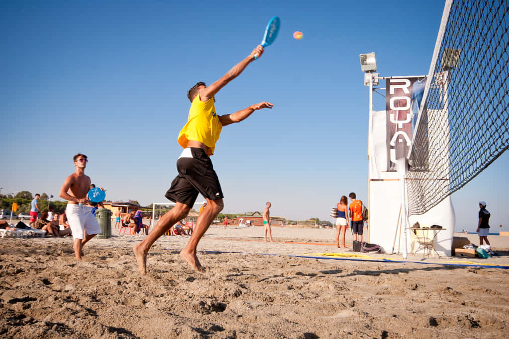 Acciónde Tenis En La Playa: Divirtiéndose Bajo El Sol. Fondo de pantalla