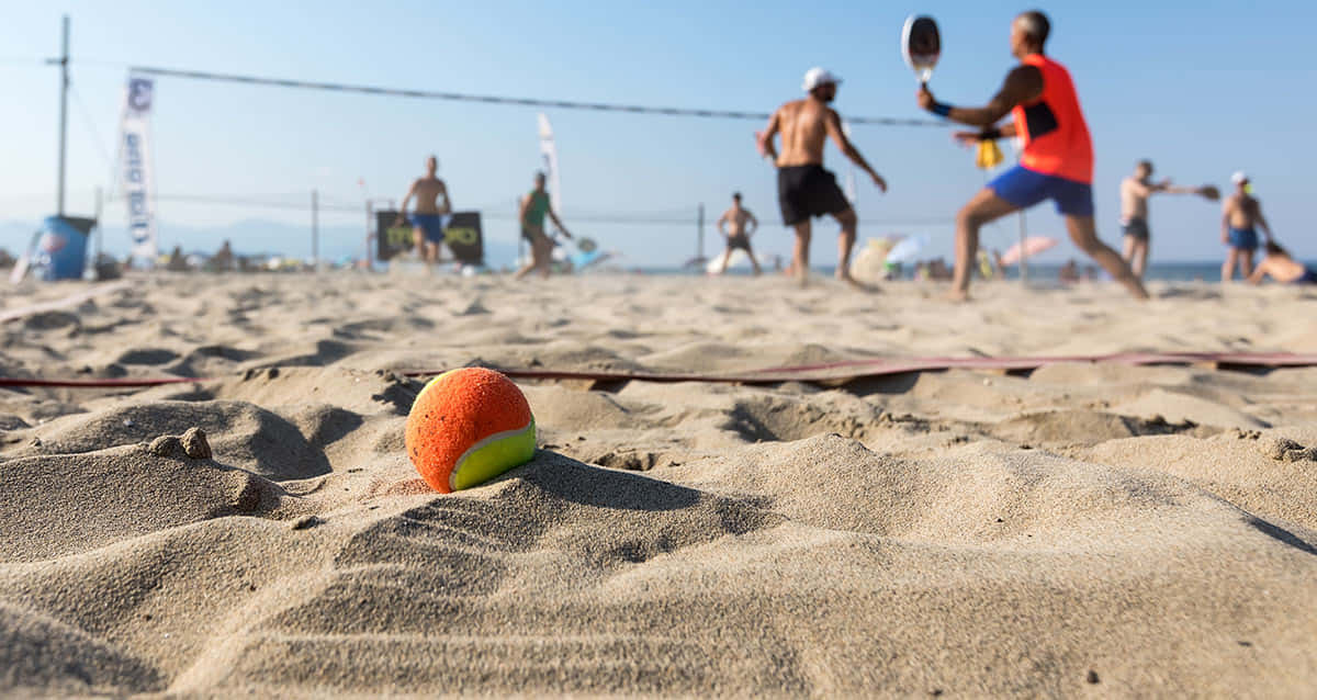 Exciting Beach Tennis Action Wallpaper