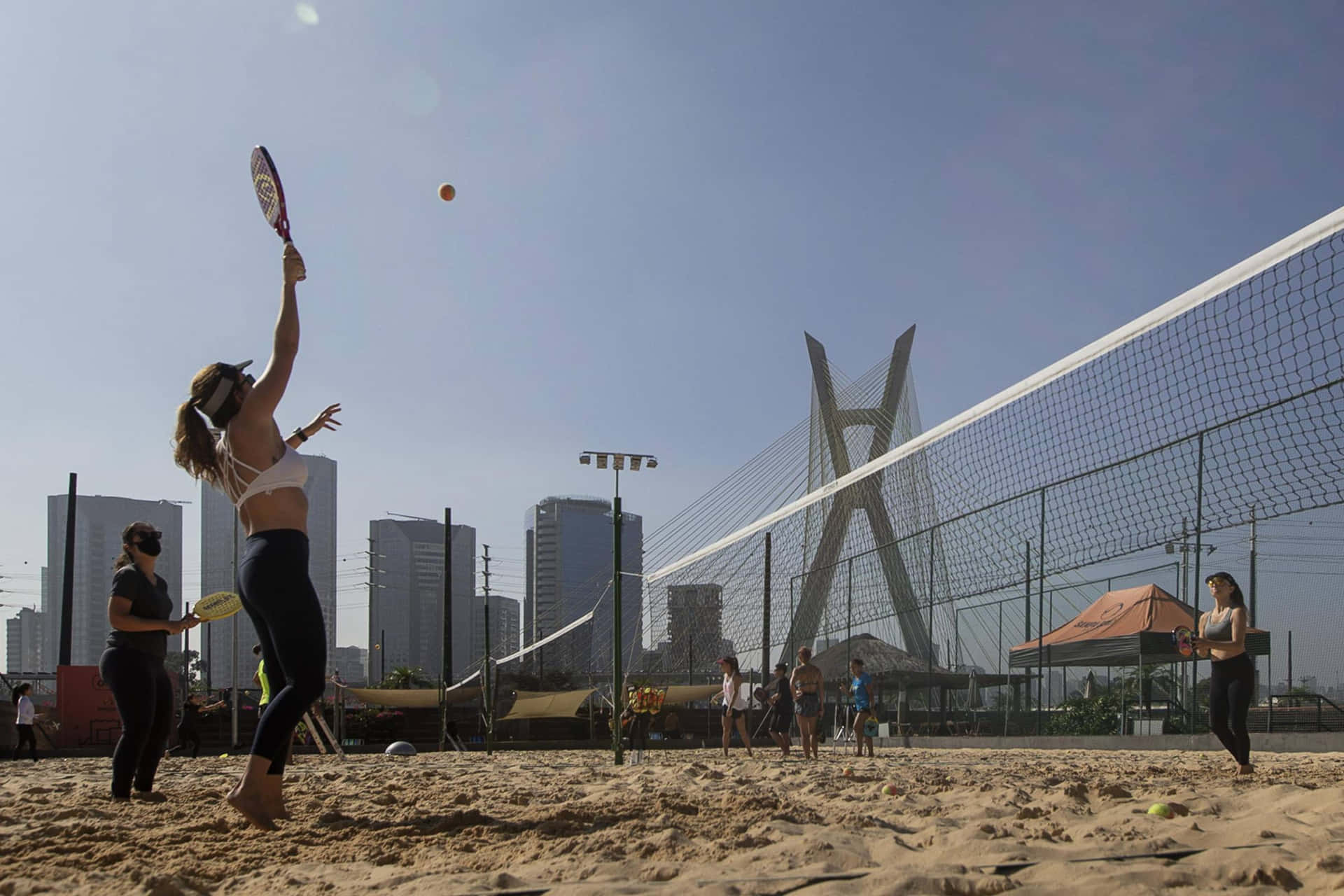 Exciting game of beach tennis in the sun Wallpaper