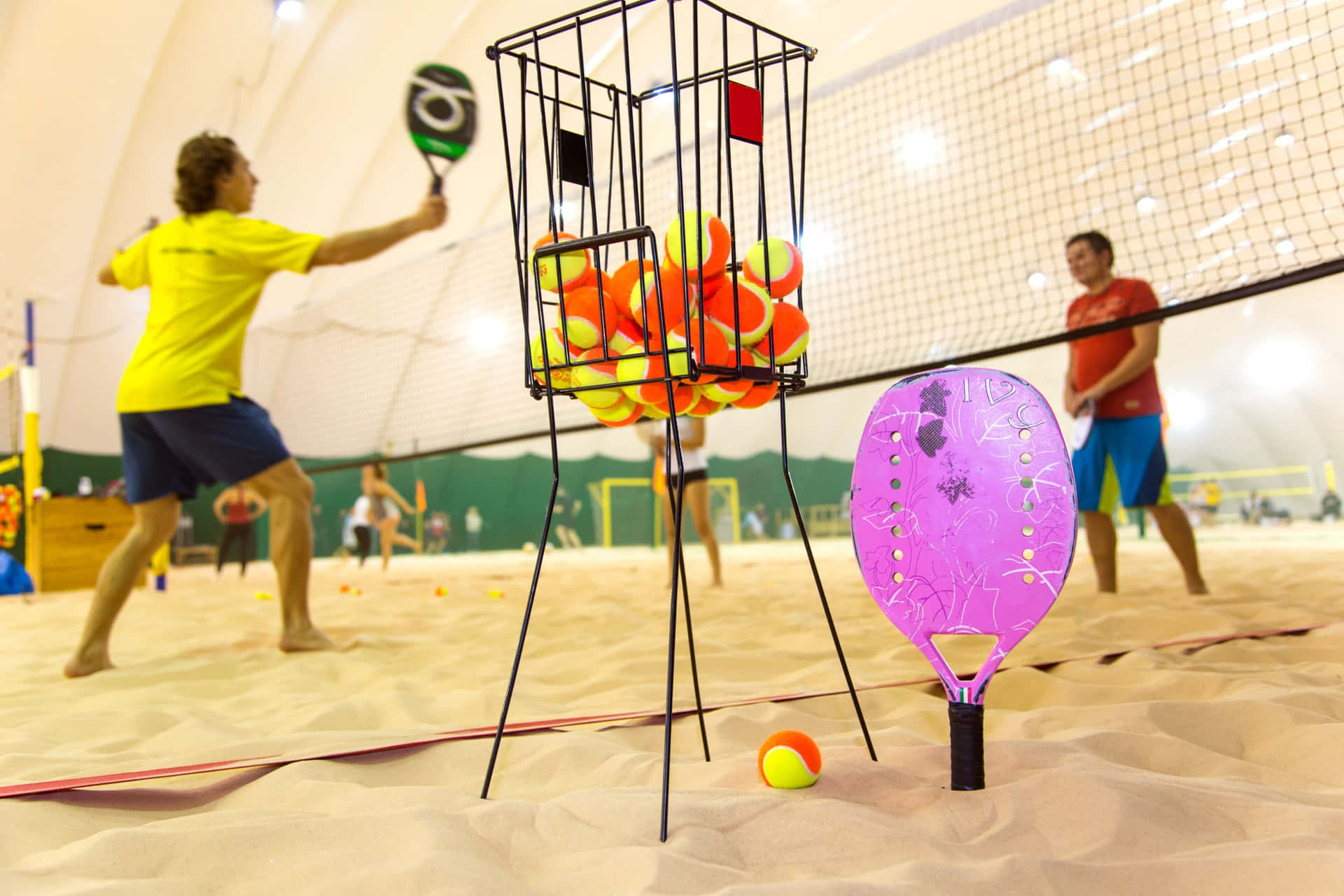 Exciting Beach Tennis Game in Action Wallpaper