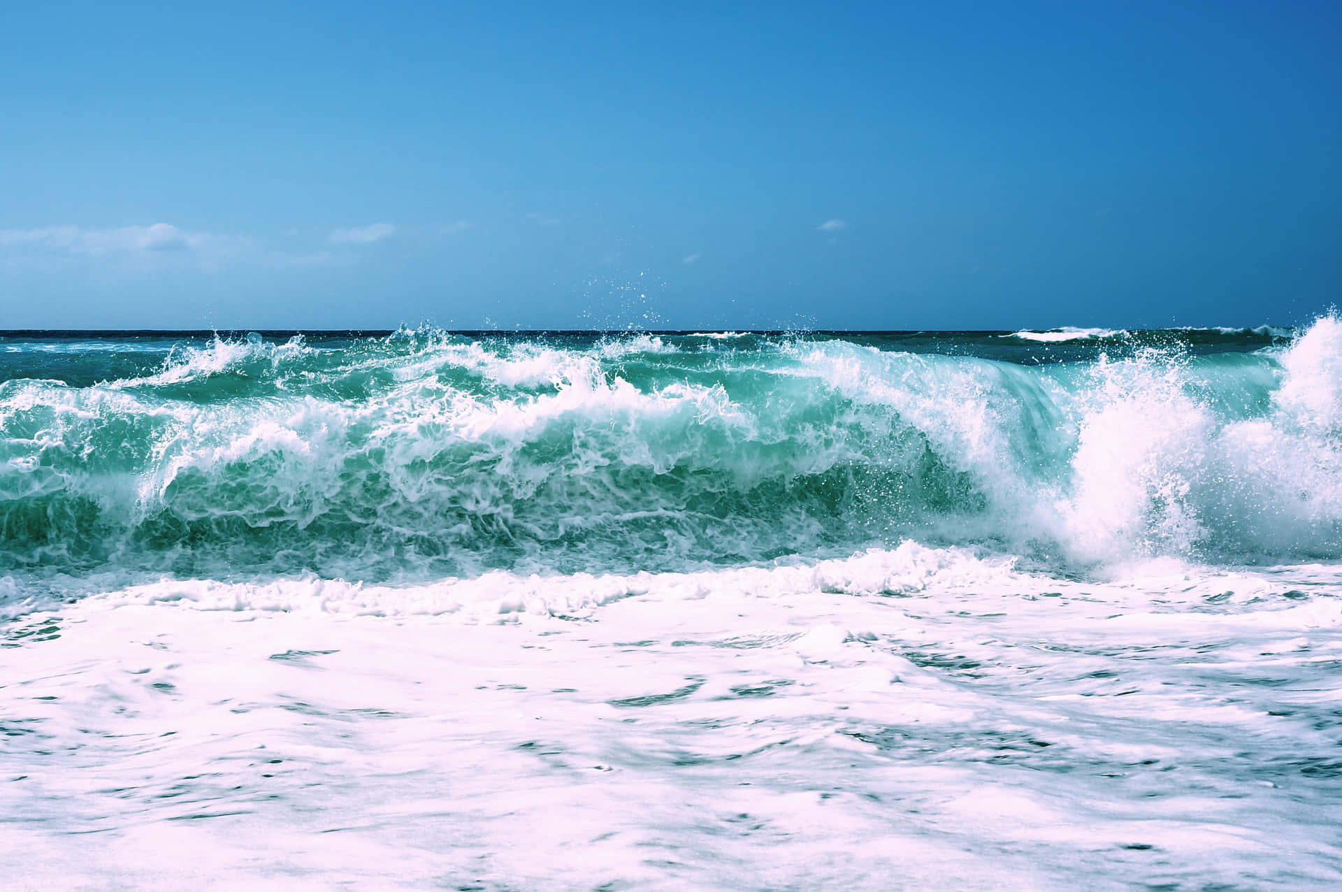 A mesmerizing beach wave at a sandy shore Wallpaper