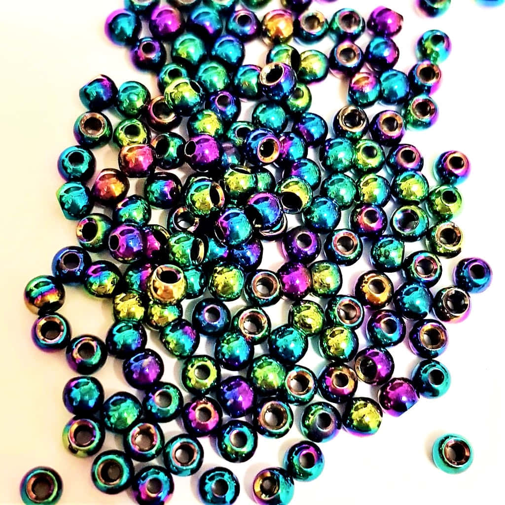 A Pile Of Colorful Beads On A White Surface