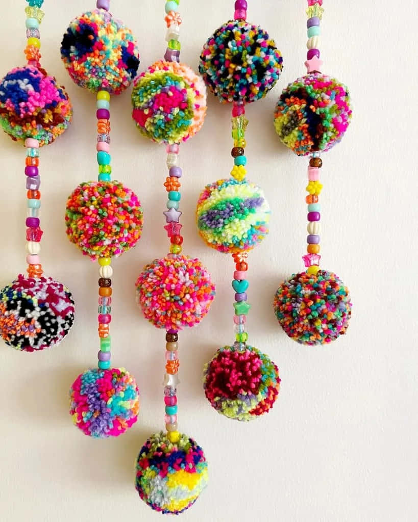 A Colorful Beaded Pom Pom Hanging From A Wall