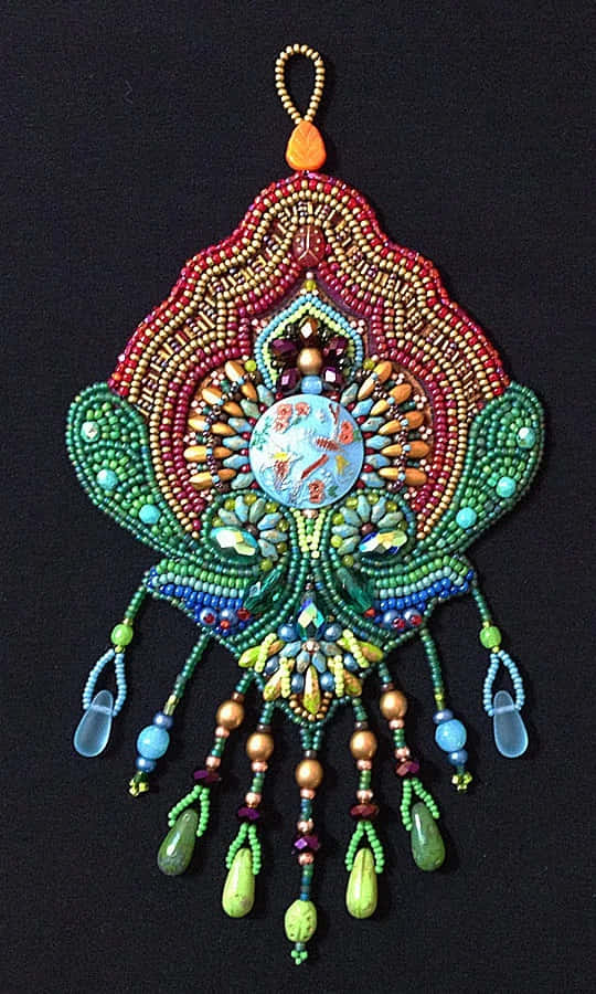 A Colorful Beaded Ornament Hanging On A Black Background