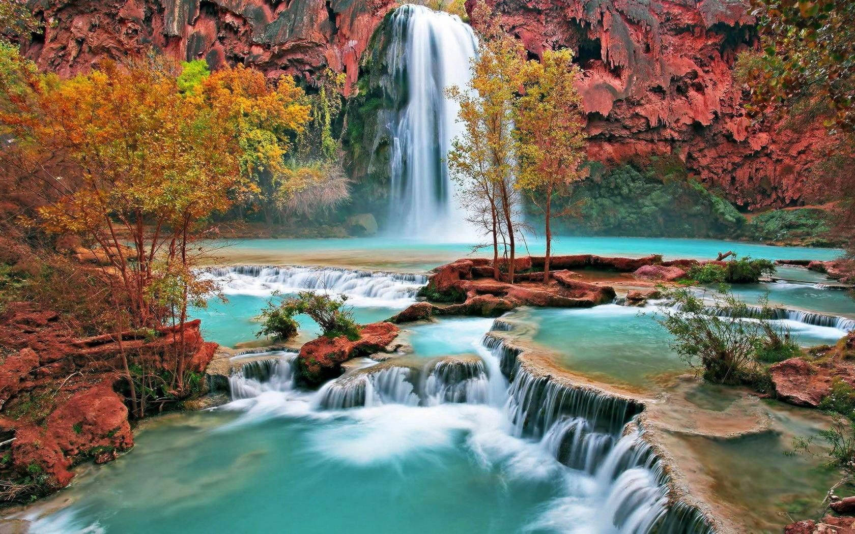 Enjoying the Sights and Sounds of a peaceful Autumn Waterfall Wallpaper