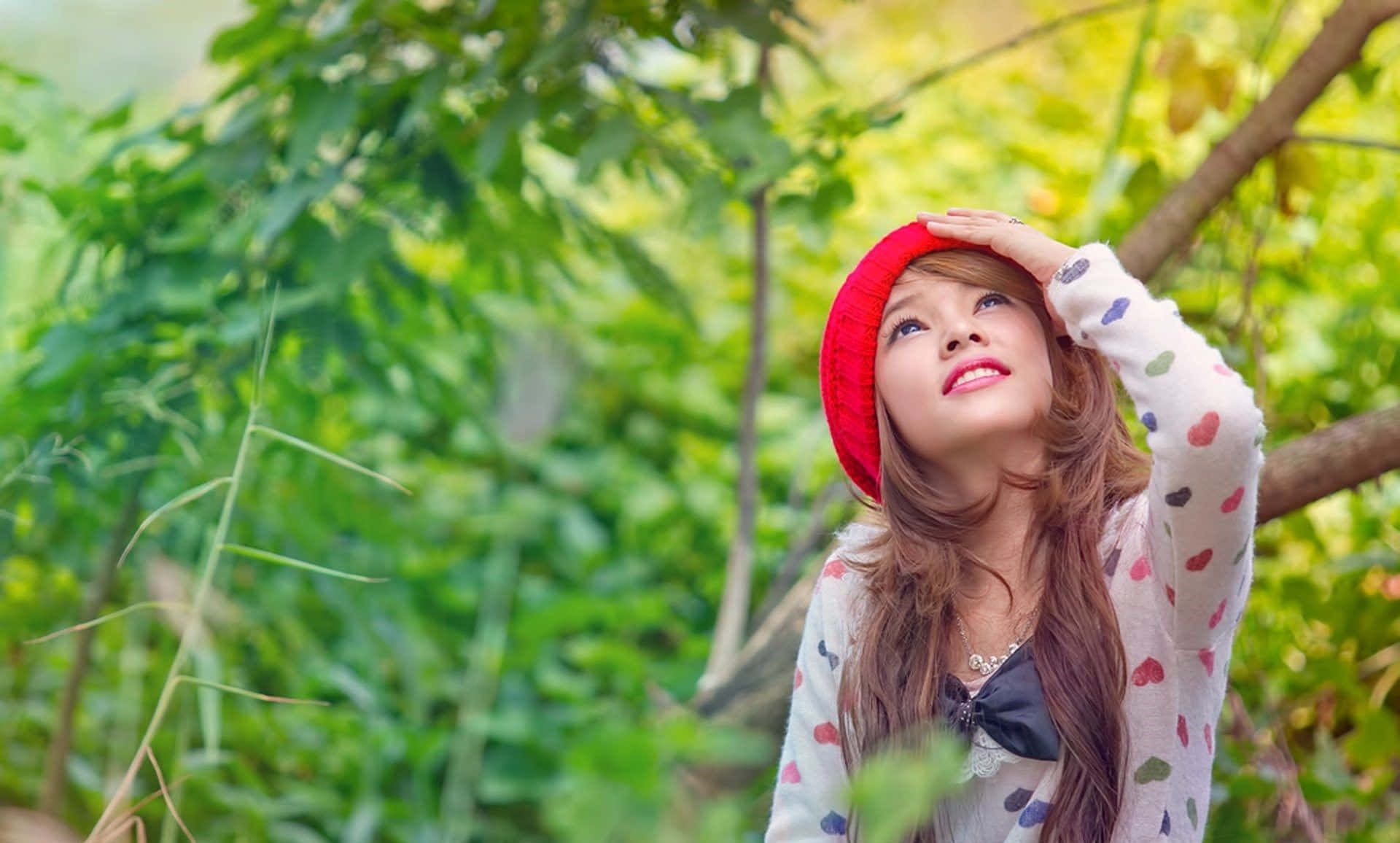 A Girl In A Red Hat Is Looking Up At The Sky