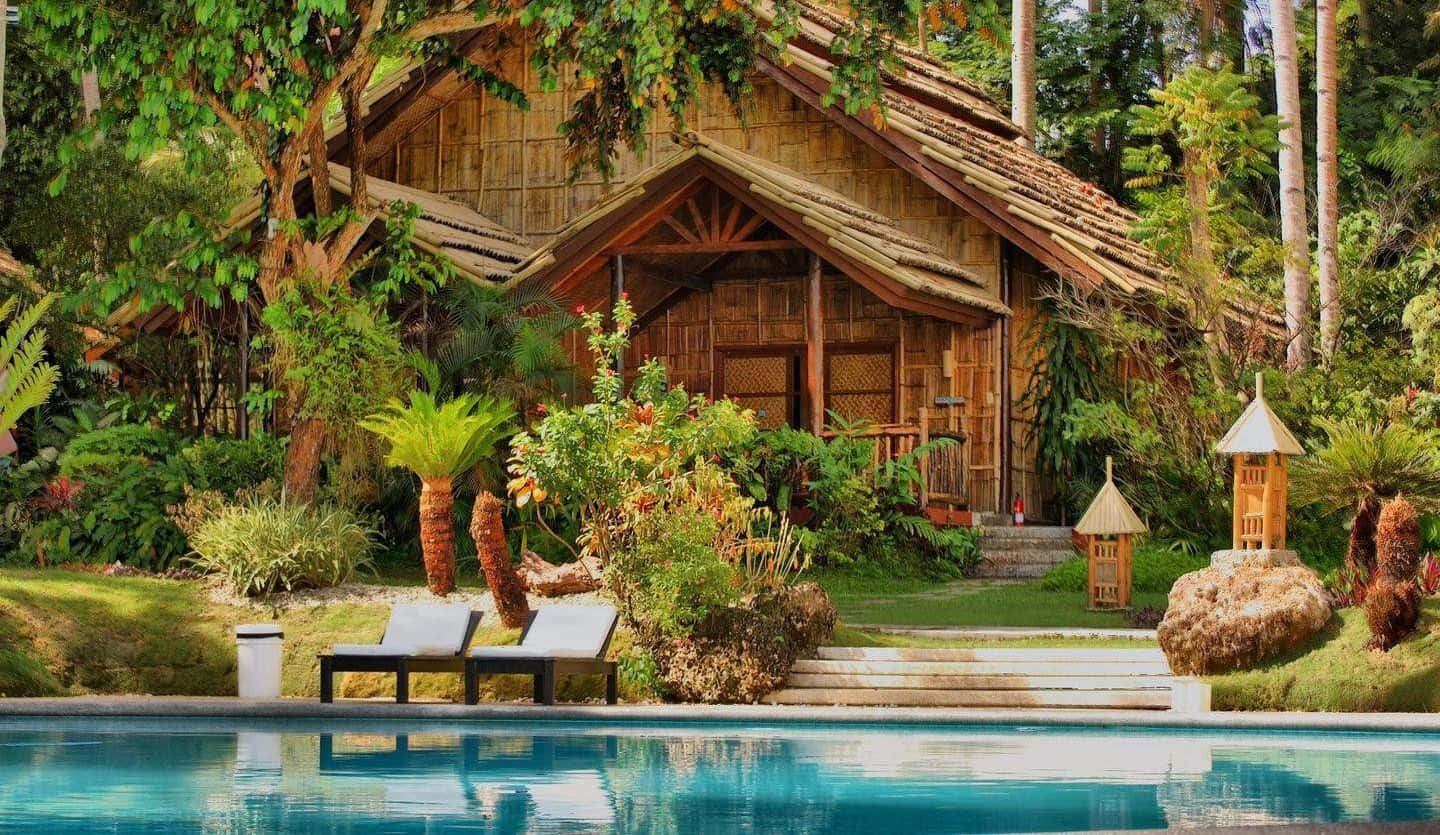 A Wooden House With A Pool And Lounge Chairs