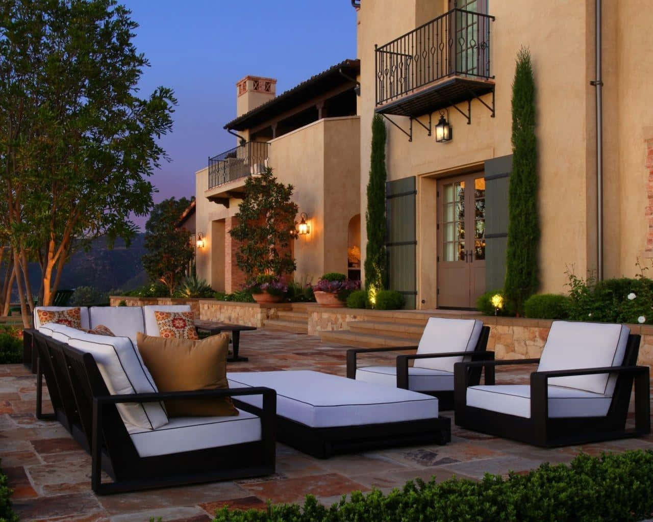 A Patio With Furniture And Lighting At Dusk