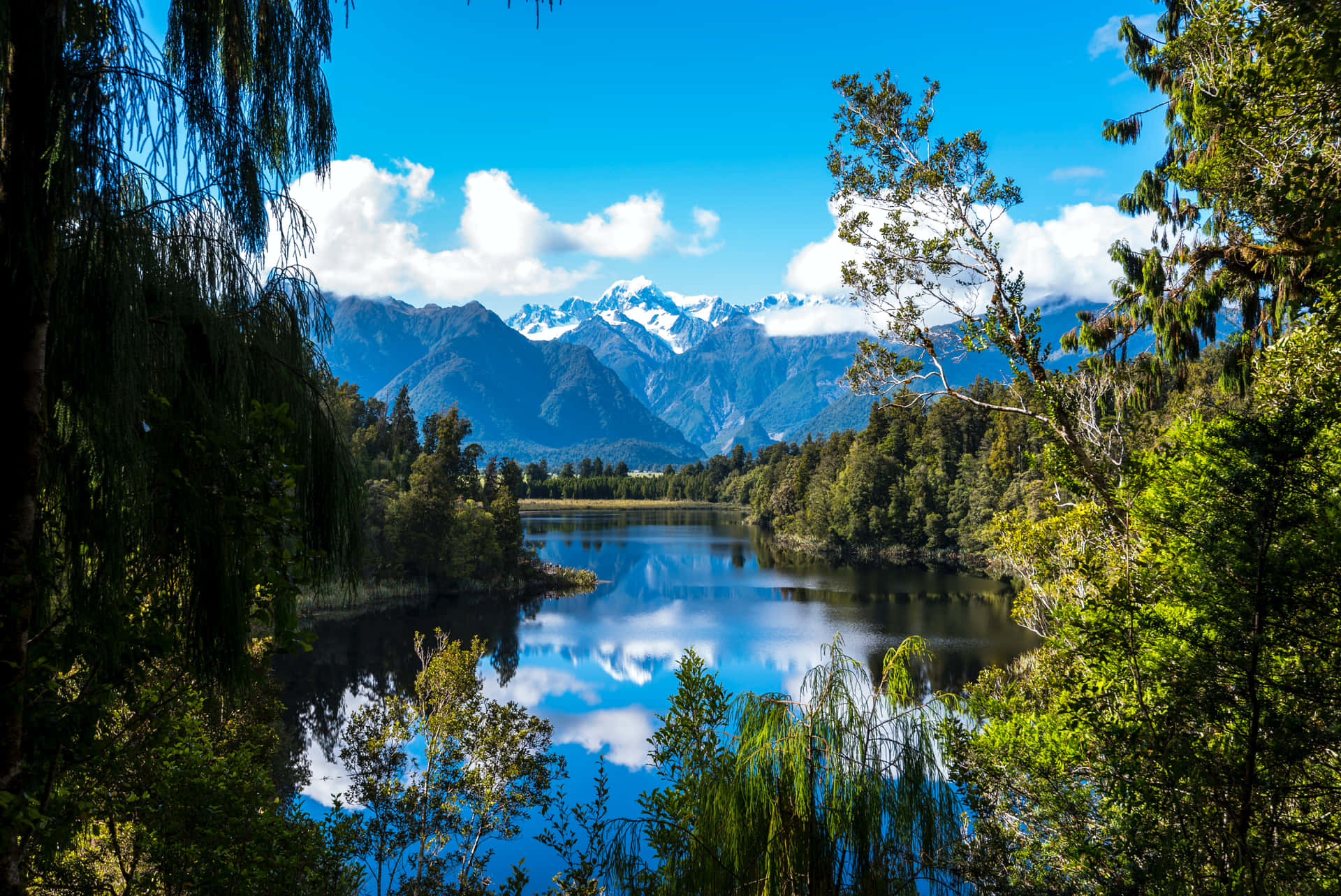 A Lake Surrounded By Trees And Mountains Wallpaper