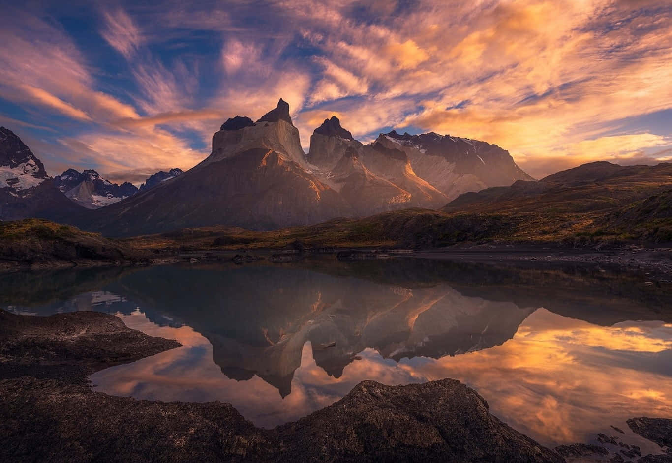 A Mountain Range Is Reflected In A Lake At Sunset